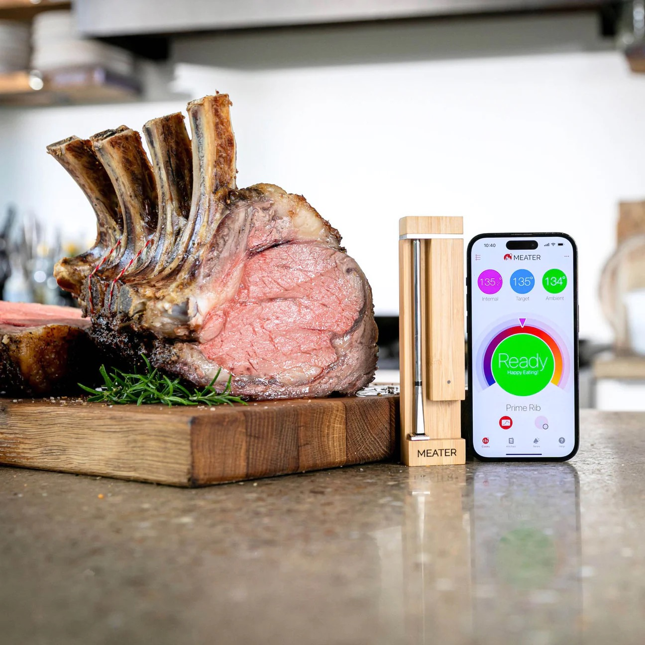 Un rôti avec os, un thermomètre à viande et un smartphone avec l'application MEATER.