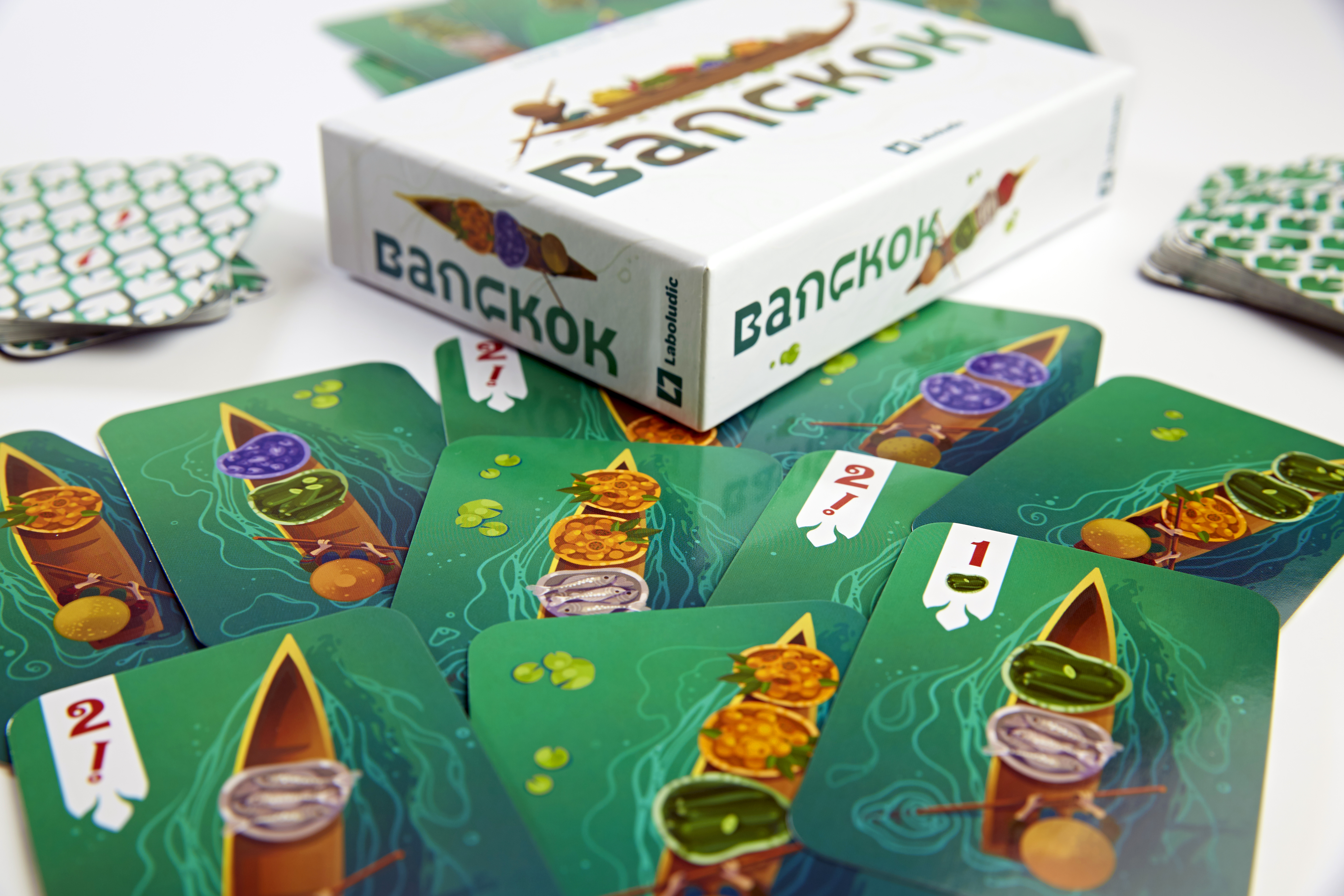 Brettspiel "Bangkok" mit Karten, die Boote mit Lebensmitteln zeigen.