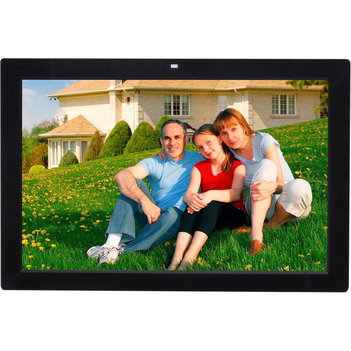 Familie sitzt auf einer Wiese vor einem Haus. Mann, Frau, Mädchen.