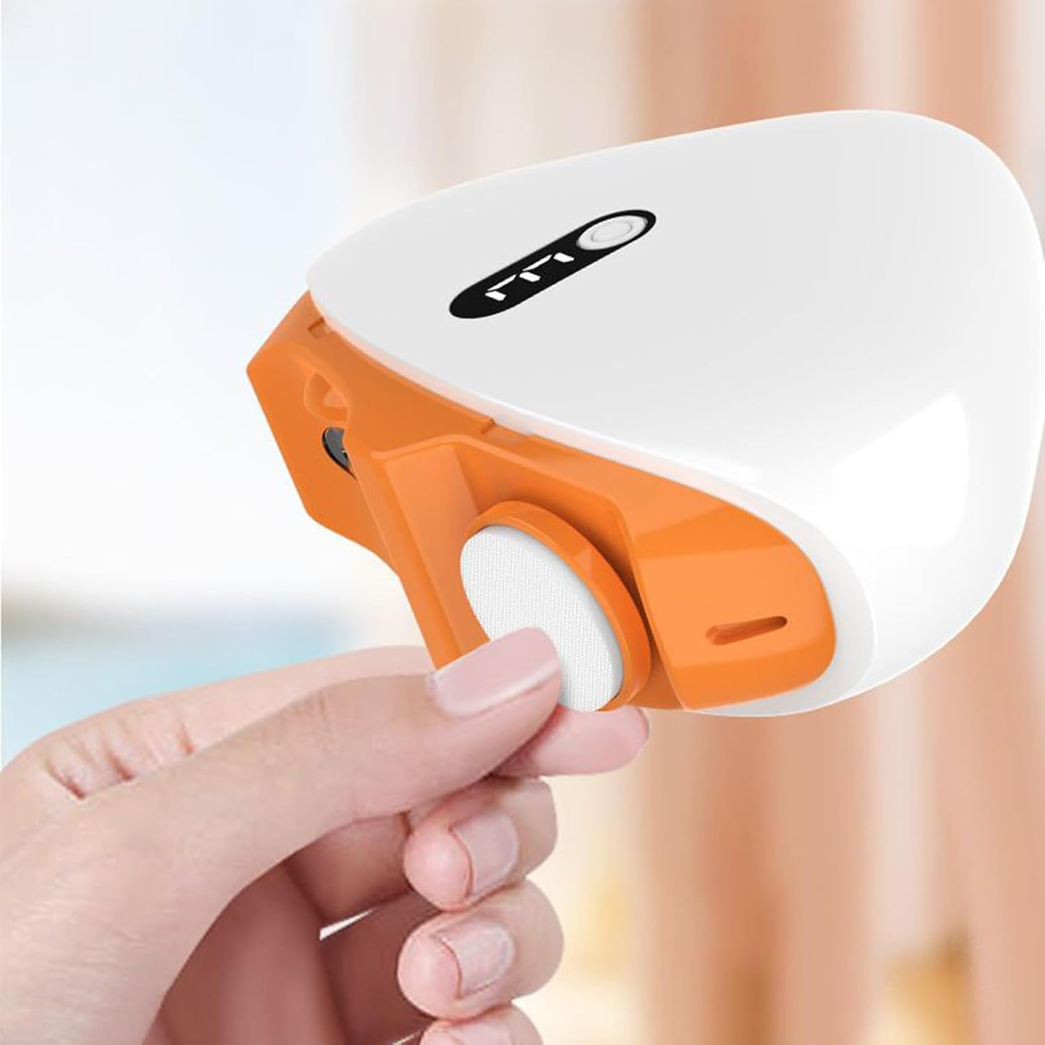 Eine Hand hält eine weiße und orange Maske mit einem weißen Filter.