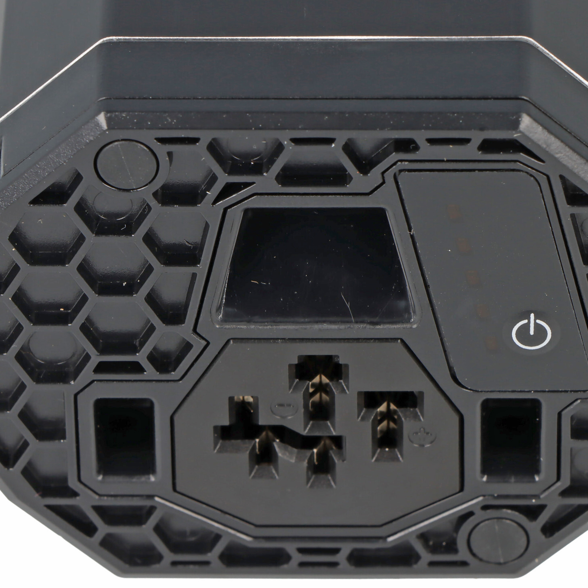 Schwarzes Gerät mit sechseckigem Muster, Anschlüssen und Power-Symbol.