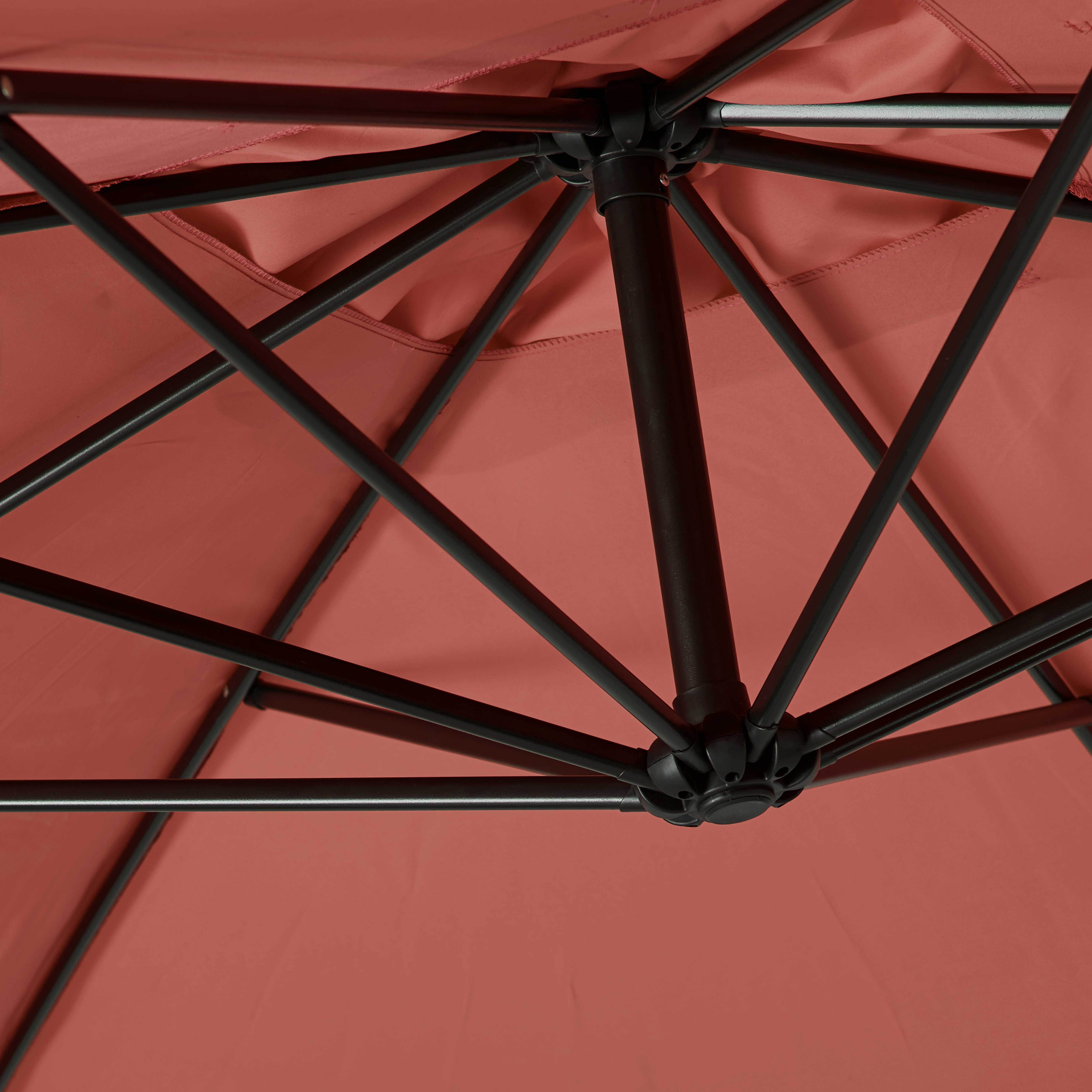 Unterseite eines roten Sonnenschirms mit schwarzem Metallgestell.