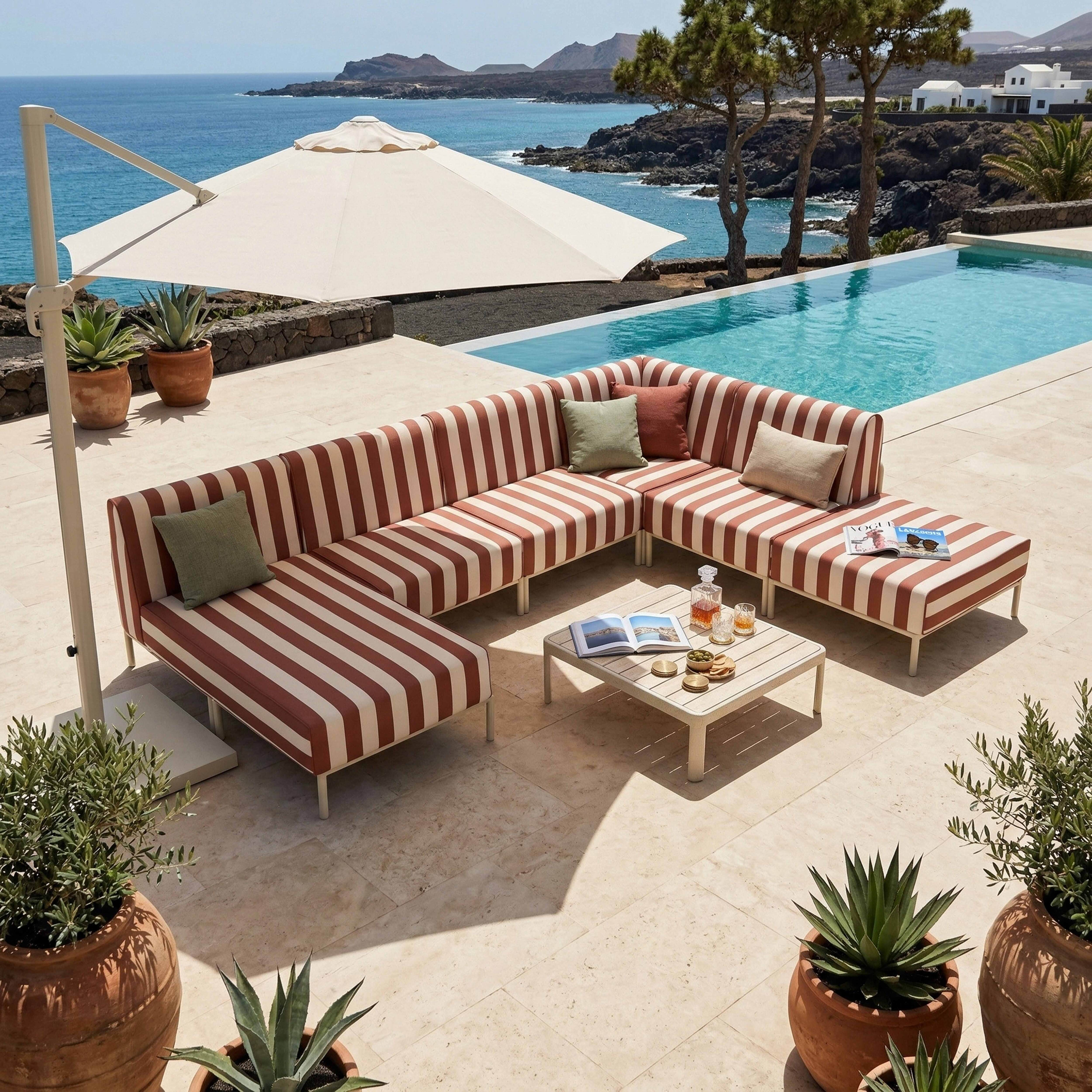 Gestreifte Lounge-Möbel am Pool mit Meerblick und Sonnenschirm.