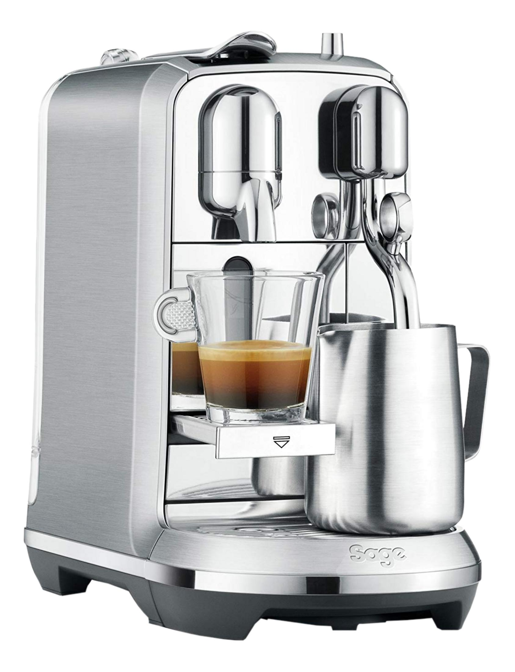 Macchina per caffè espresso argentata con tazza di vetro con caffè e lattiera.
