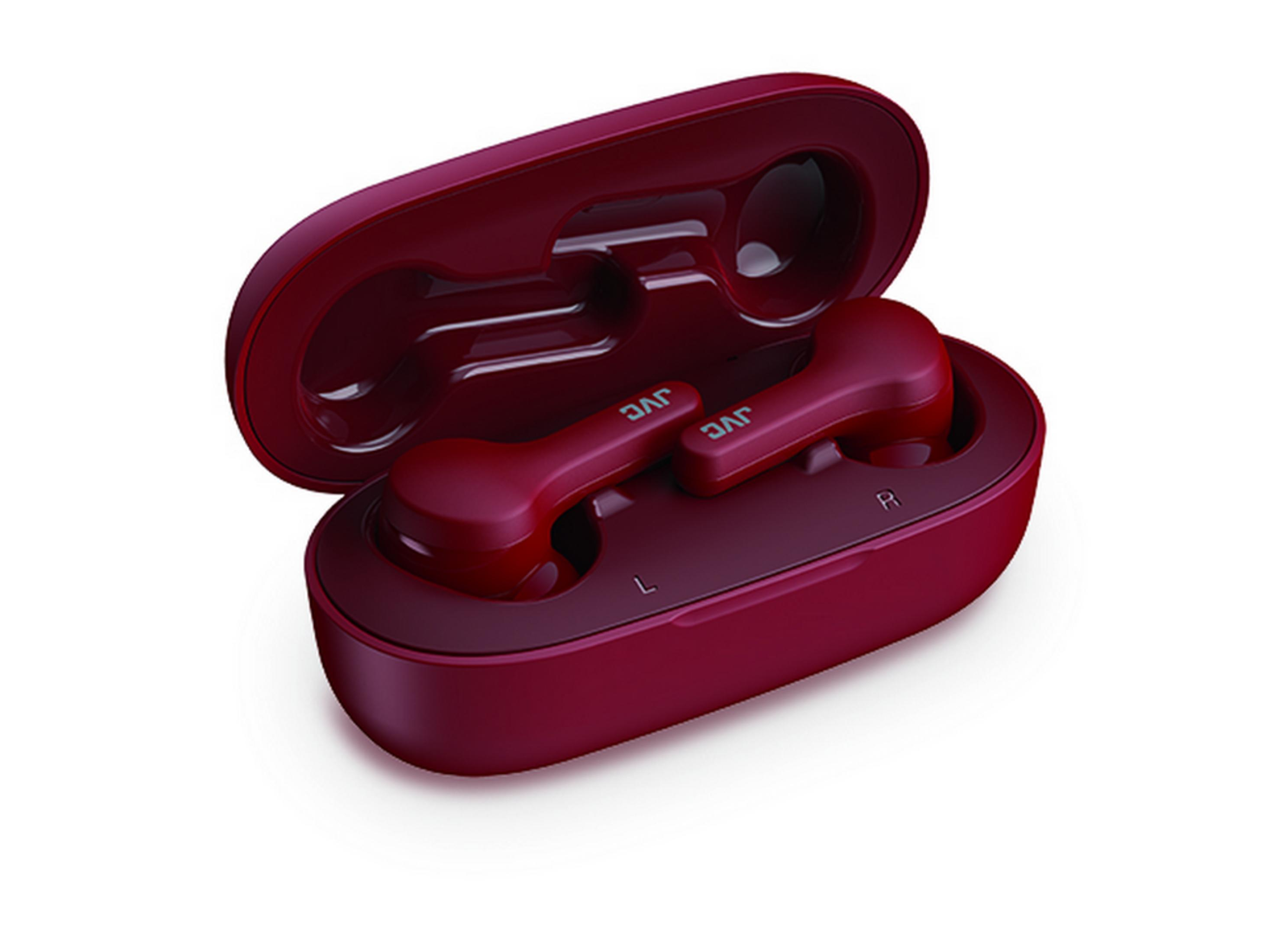 Czerwone słuchawki JVC z etui ładującym na białym tle.