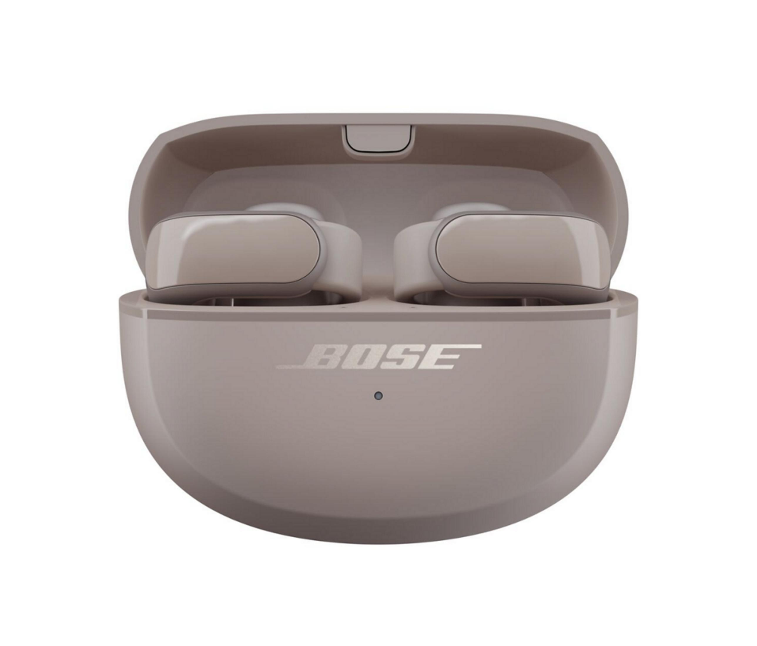 Słuchawki douszne Bose w otwartym, beżowym etui ładującym ze srebrnymi akcentami.