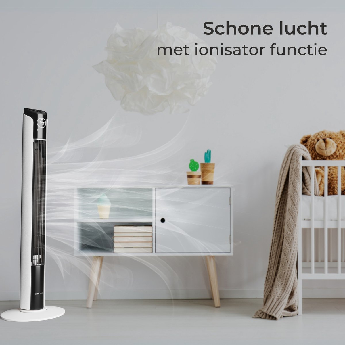 Ein weißer Turmlüfter mit einem Display gibt Luft ab. Daneben ein Schrank mit Deko und ein Kinderbett.