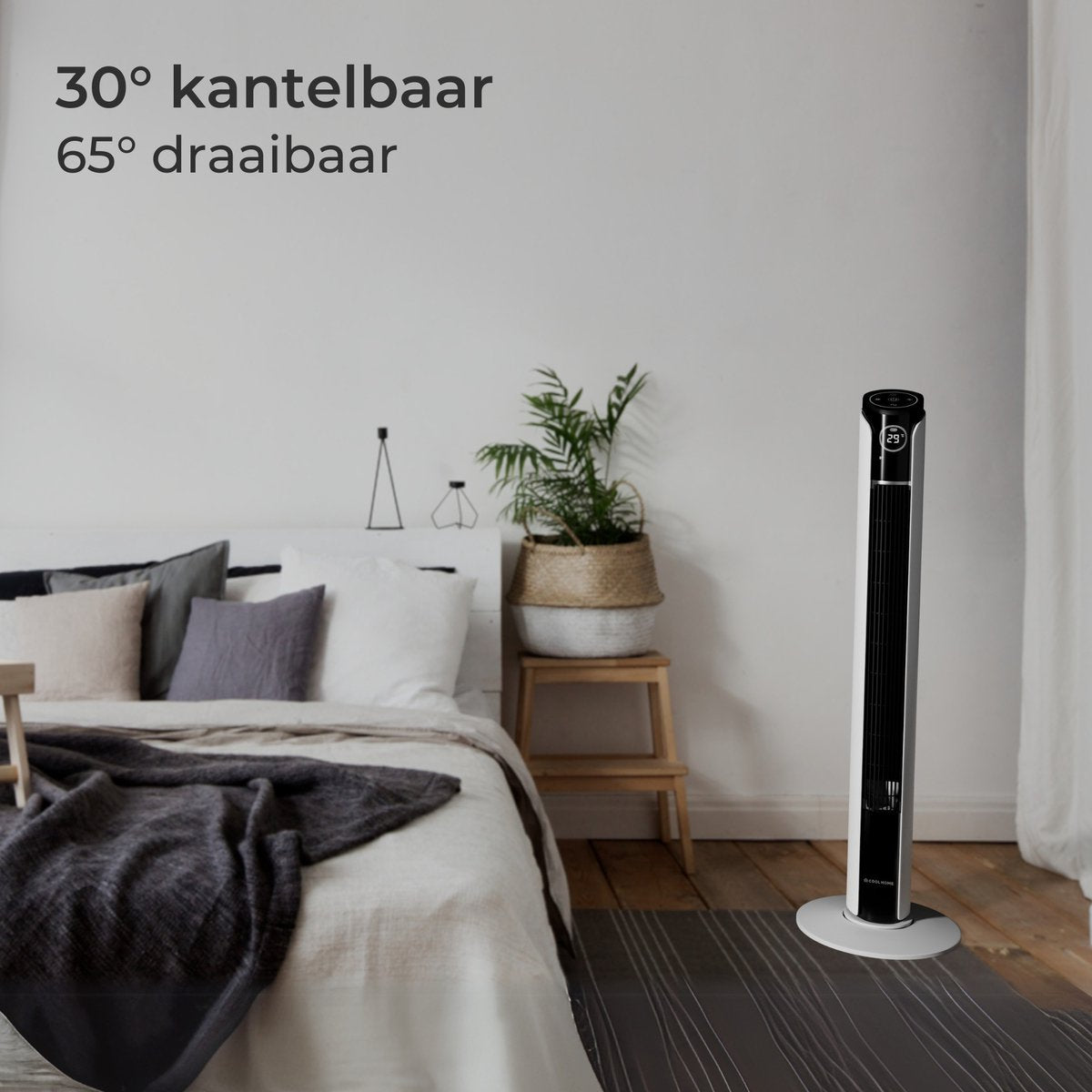 Ein schlanker weißer Turmventilator neben einem Bett mit Kissen und Decken.