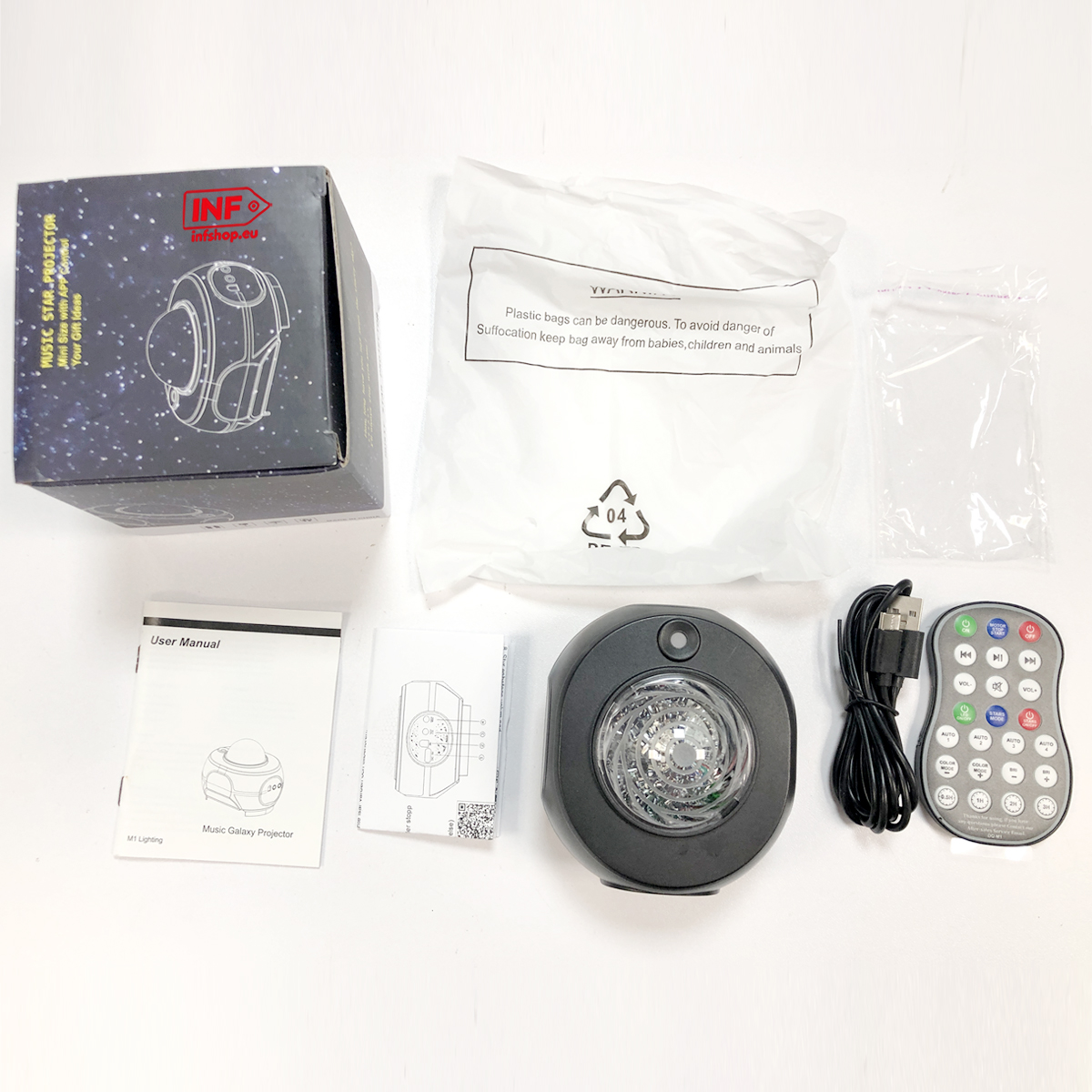 Projektor gwiazd, pilot, kabel USB i instrukcja na białym tle.