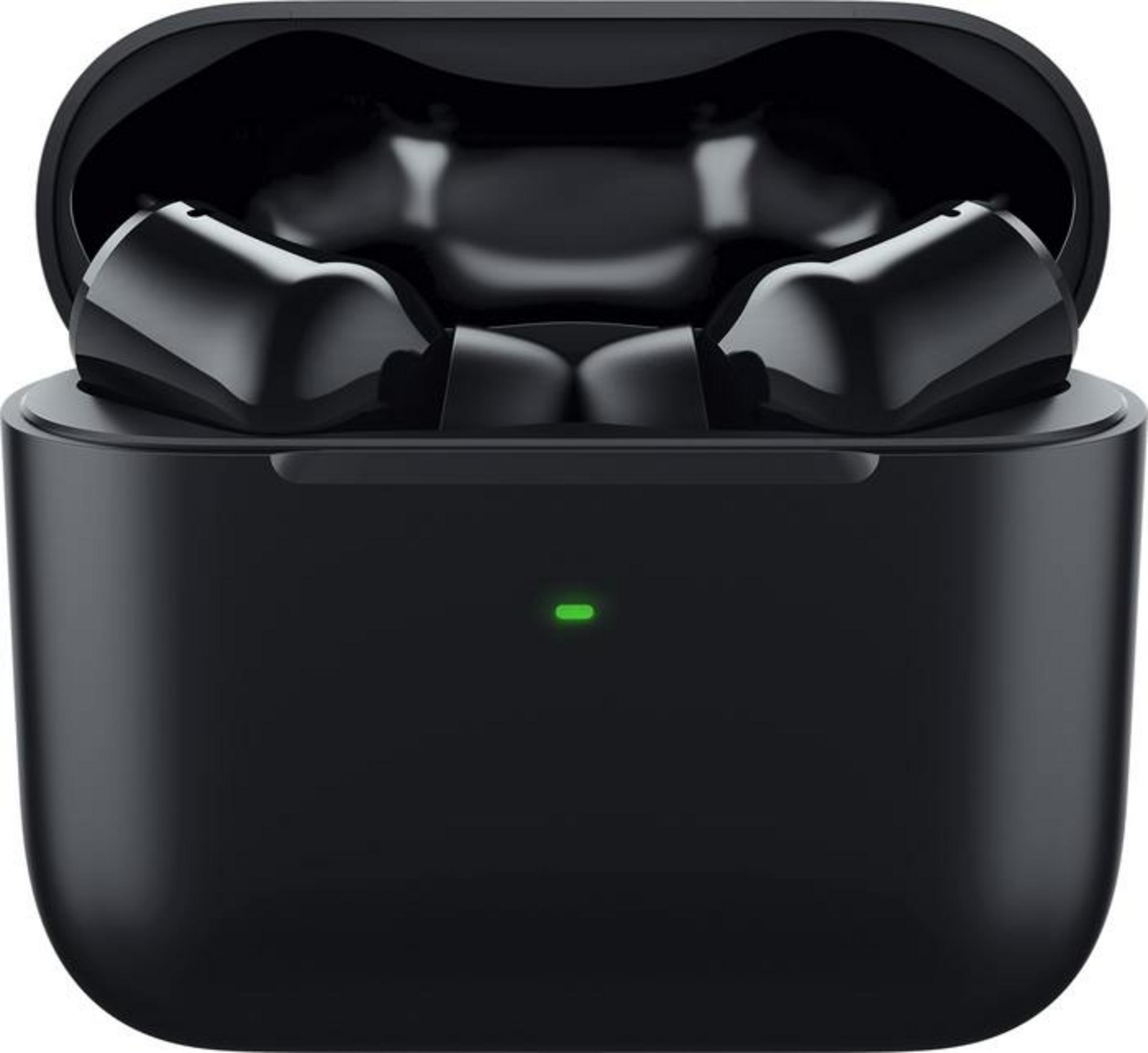 Czarne słuchawki bezprzewodowe w czarnym etui ładującym z zielonym światłem.