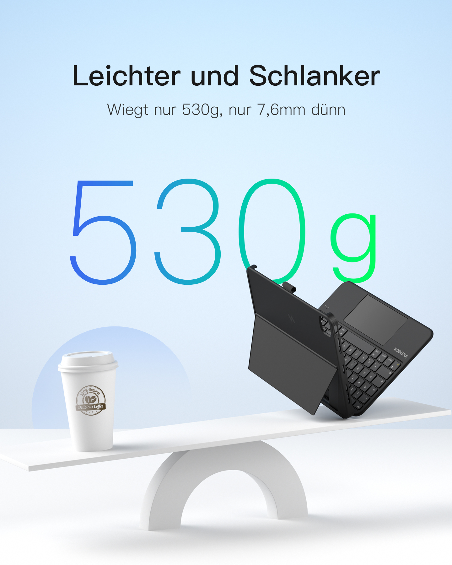Eine Waage zeigt ein Tablet mit Tastatur und einen Kaffeebecher. 530g.