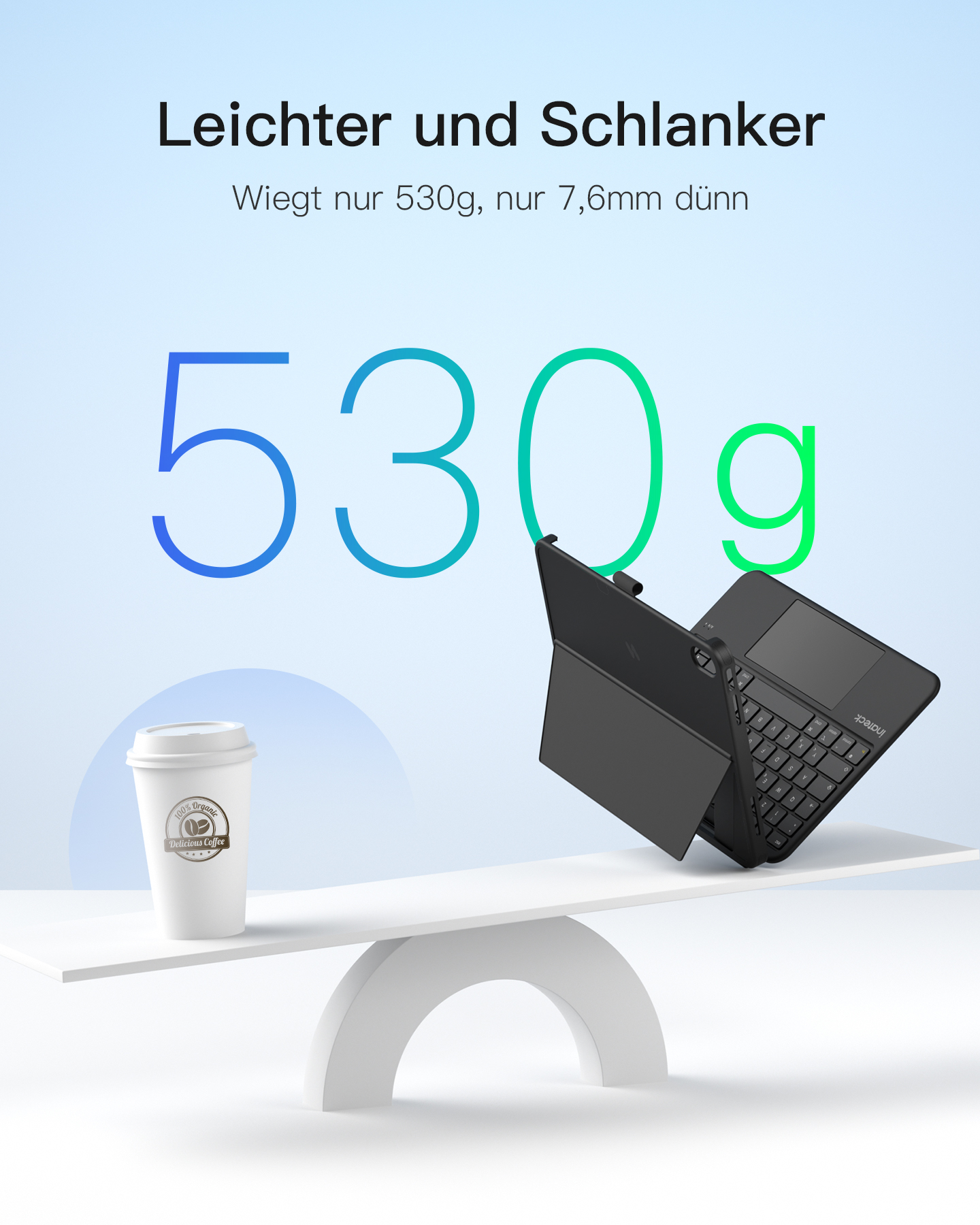 Ein schwarzes Tablet mit Tastatur und eine Kaffeetasse auf einer Waage. 530g.