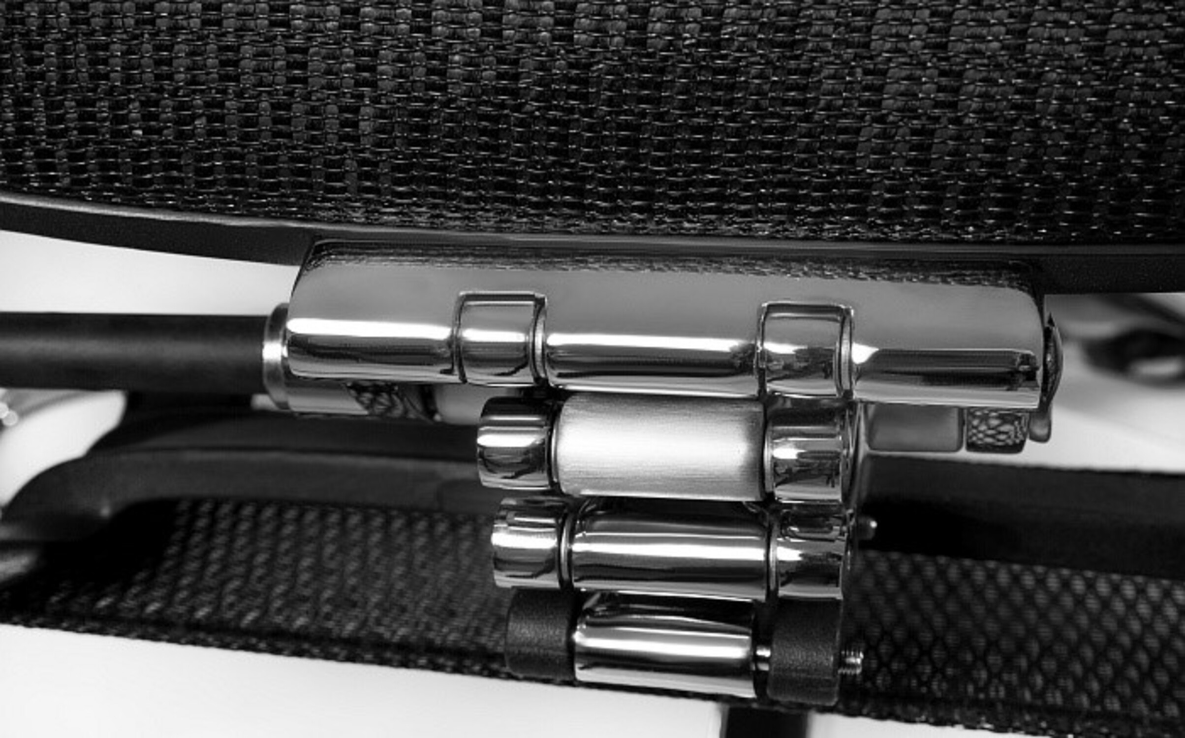 Zbliżenie srebrnego łańcucha z pierścieniami na czarnej tkaninie.