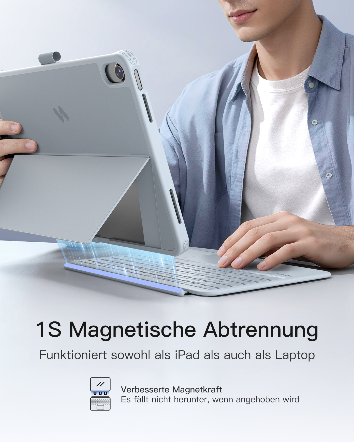Mann hält ein graues Tablet mit Tastatur. Magnetische Trennung.