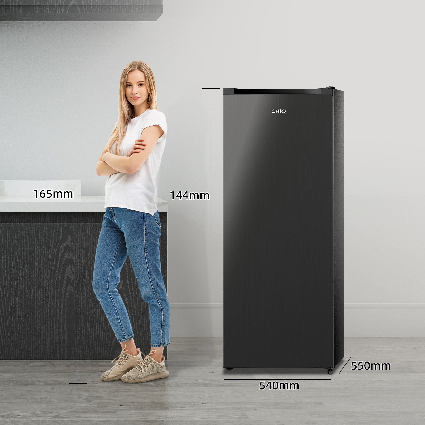 Una mujer junto a un refrigerador negro, se muestran las dimensiones.