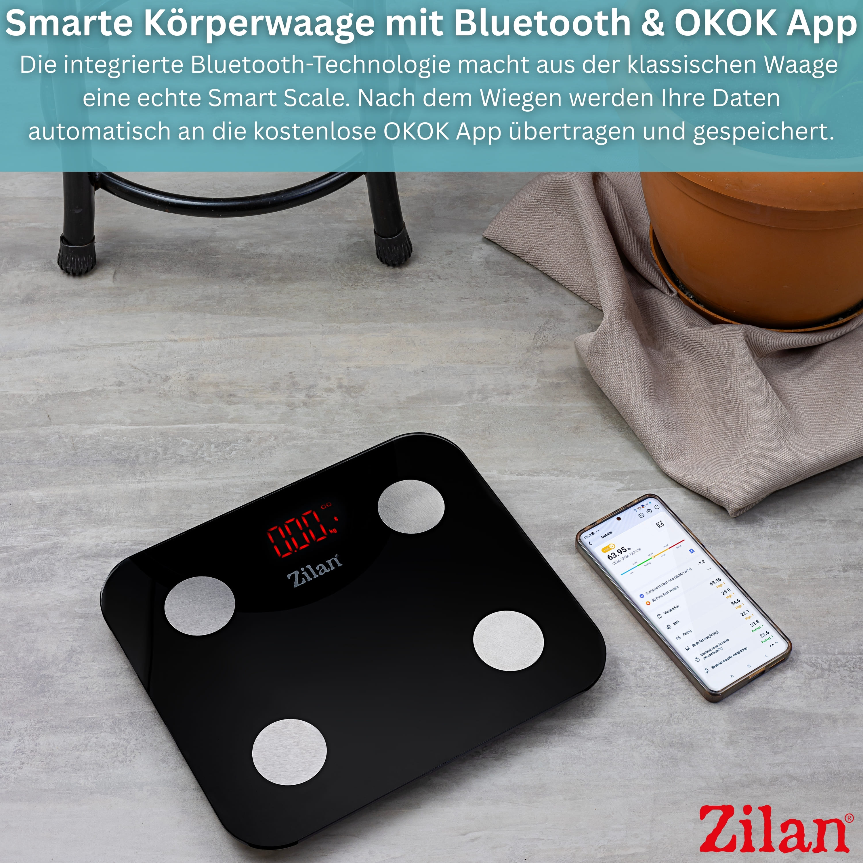 Schwarze Körperwaage mit App-Anzeige auf Handy. "0.00" auf Waage.