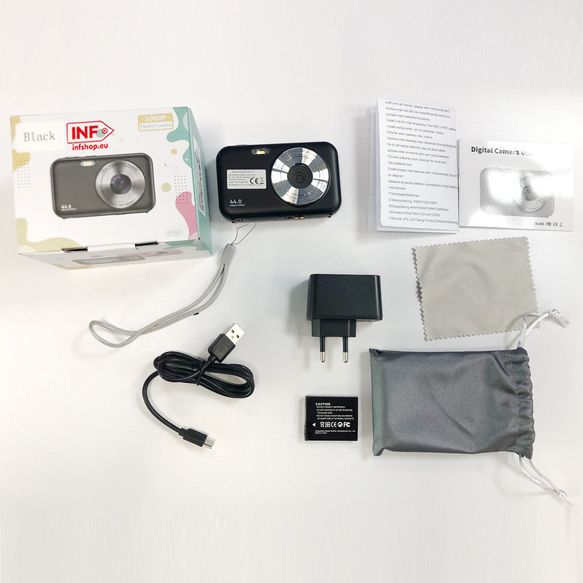 Zestaw aparatu cyfrowego z akcesoriami: aparat, kabel ładujący, ładowarka, bateria, ściereczka, torba.