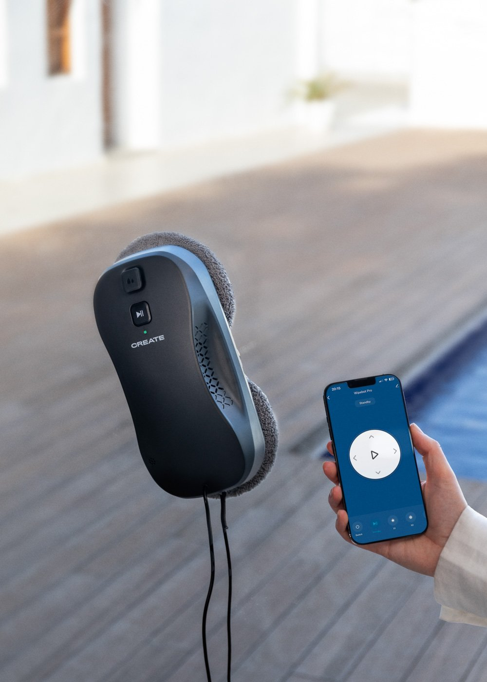 Un robot lavavetri aderisce a una finestra, controllato da uno smartphone.