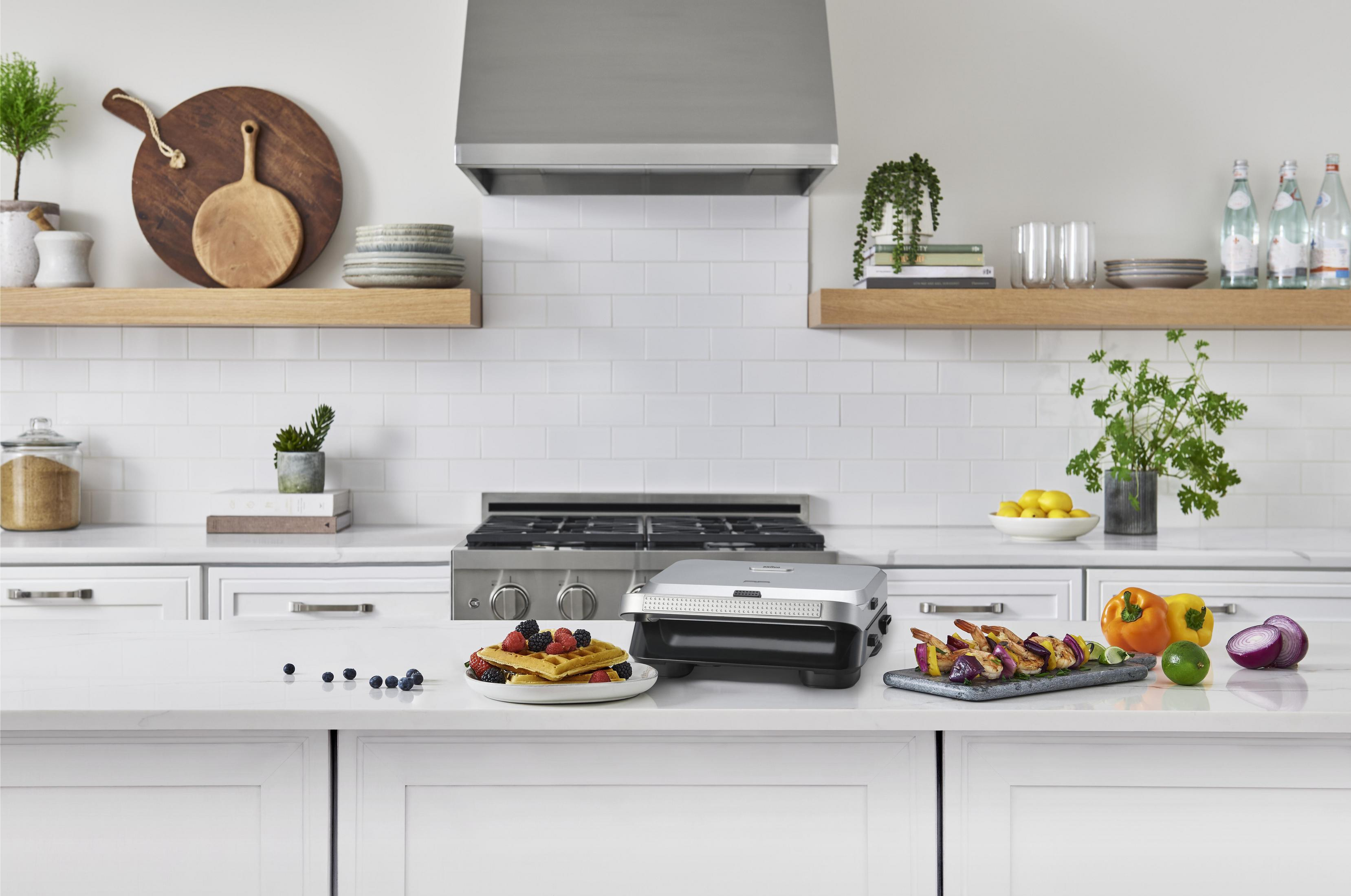 Een modern aanrecht met wafels, garnalenspiesen, groenten en een grill.