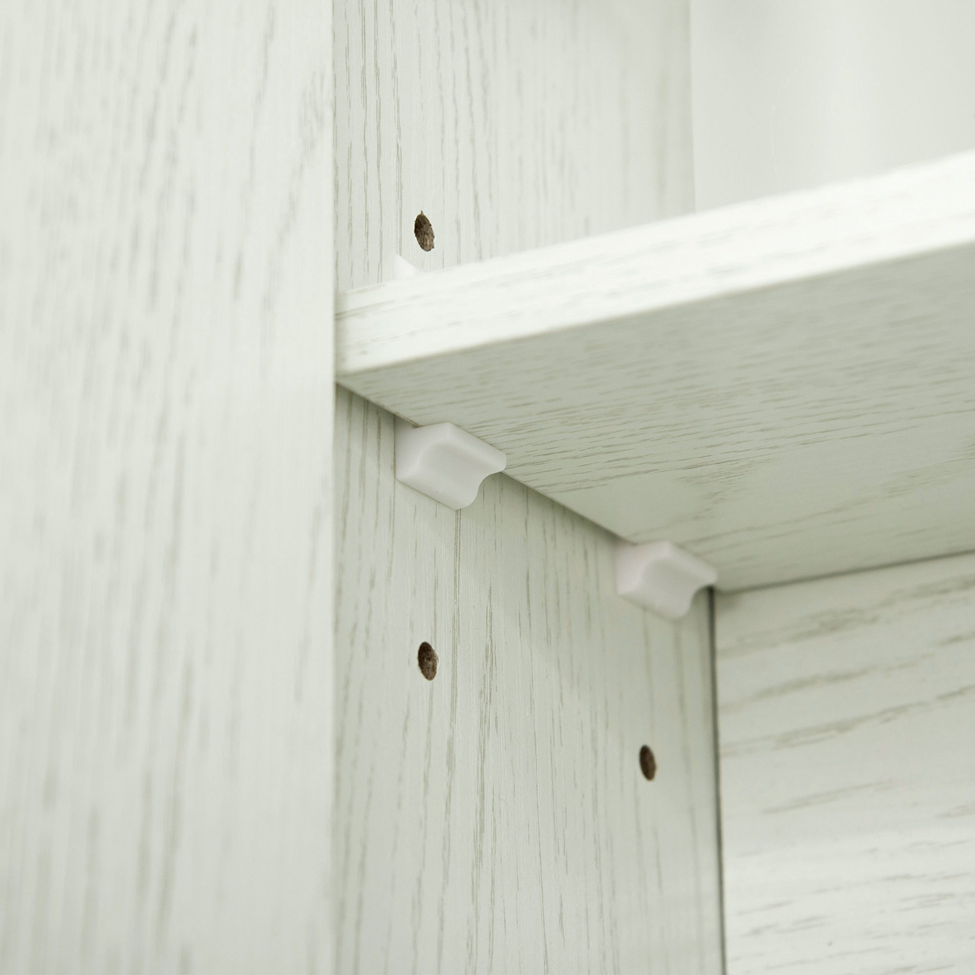 Soportes de estante blancos en un estante de madera clara. Vista cercana.