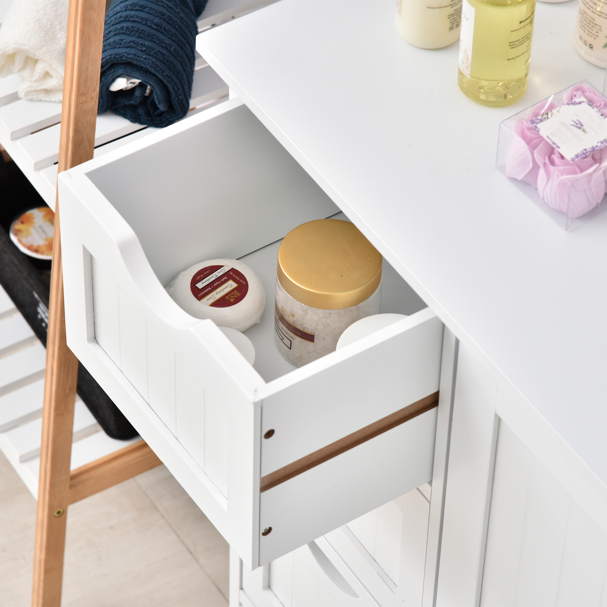 Estante de baño blanco abierto con toallas, sales de baño y jabones.