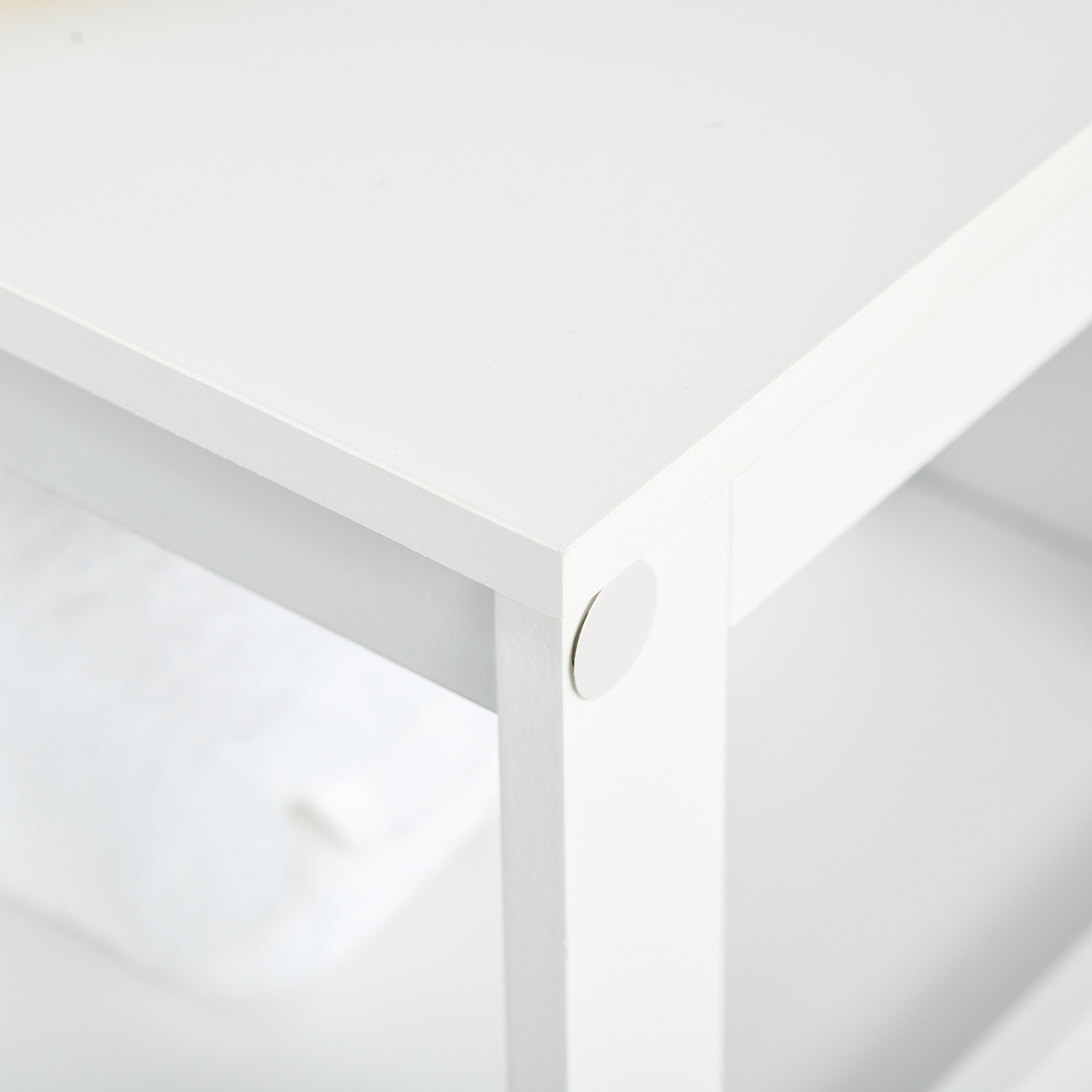 Primer plano de la esquina blanca de un mueble con una pegatina redonda blanca.