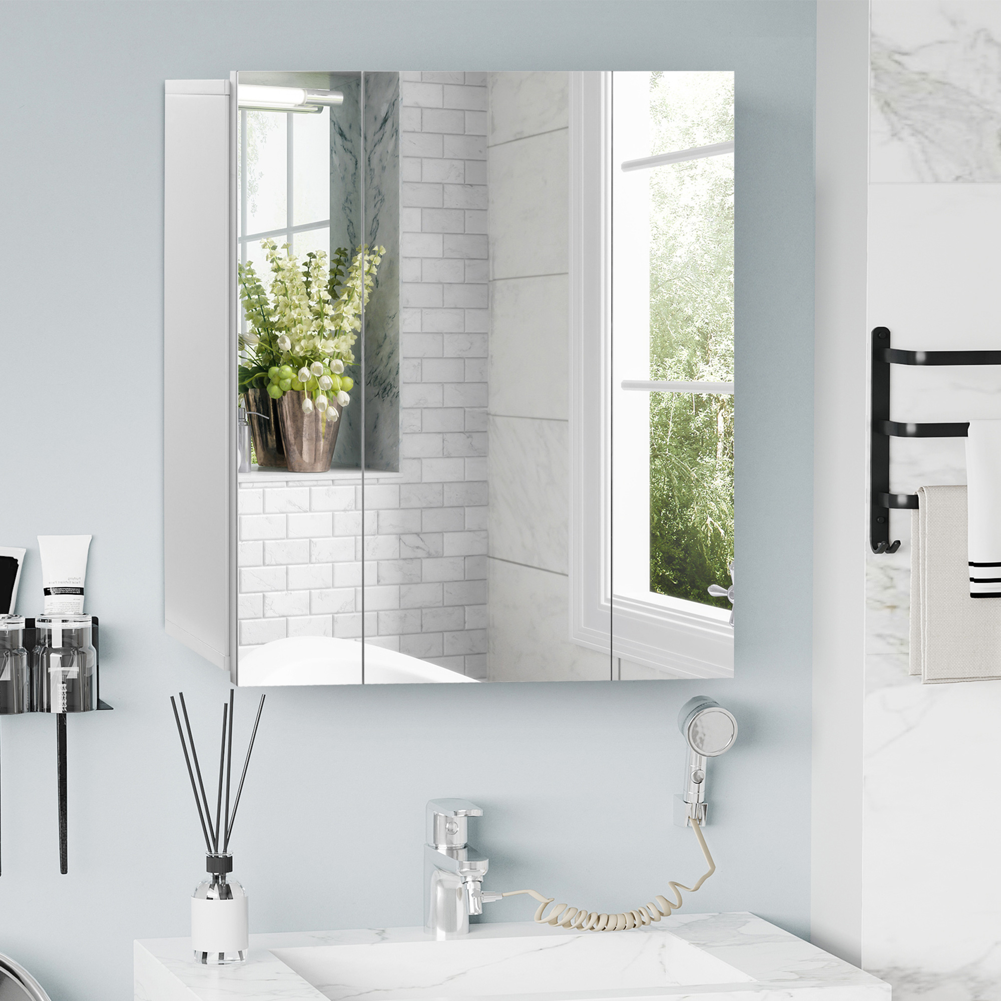Un mueble blanco con espejo sobre un lavabo con grifo y difusor.