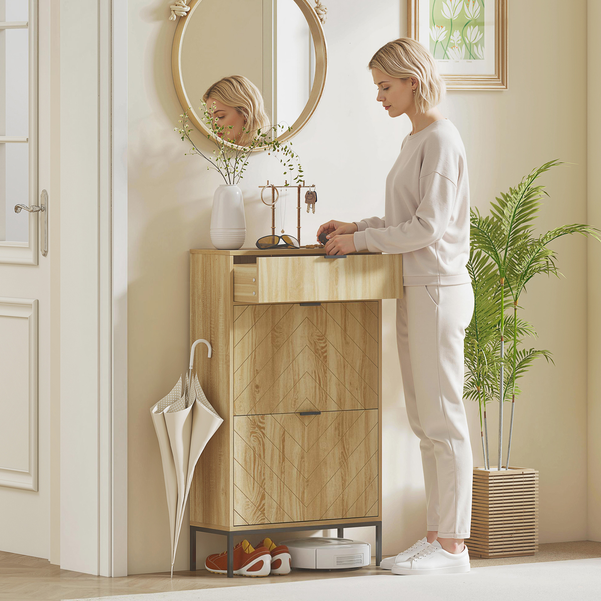 Una mujer está junto a un mueble estrecho de madera con espejo. Un robot aspira.