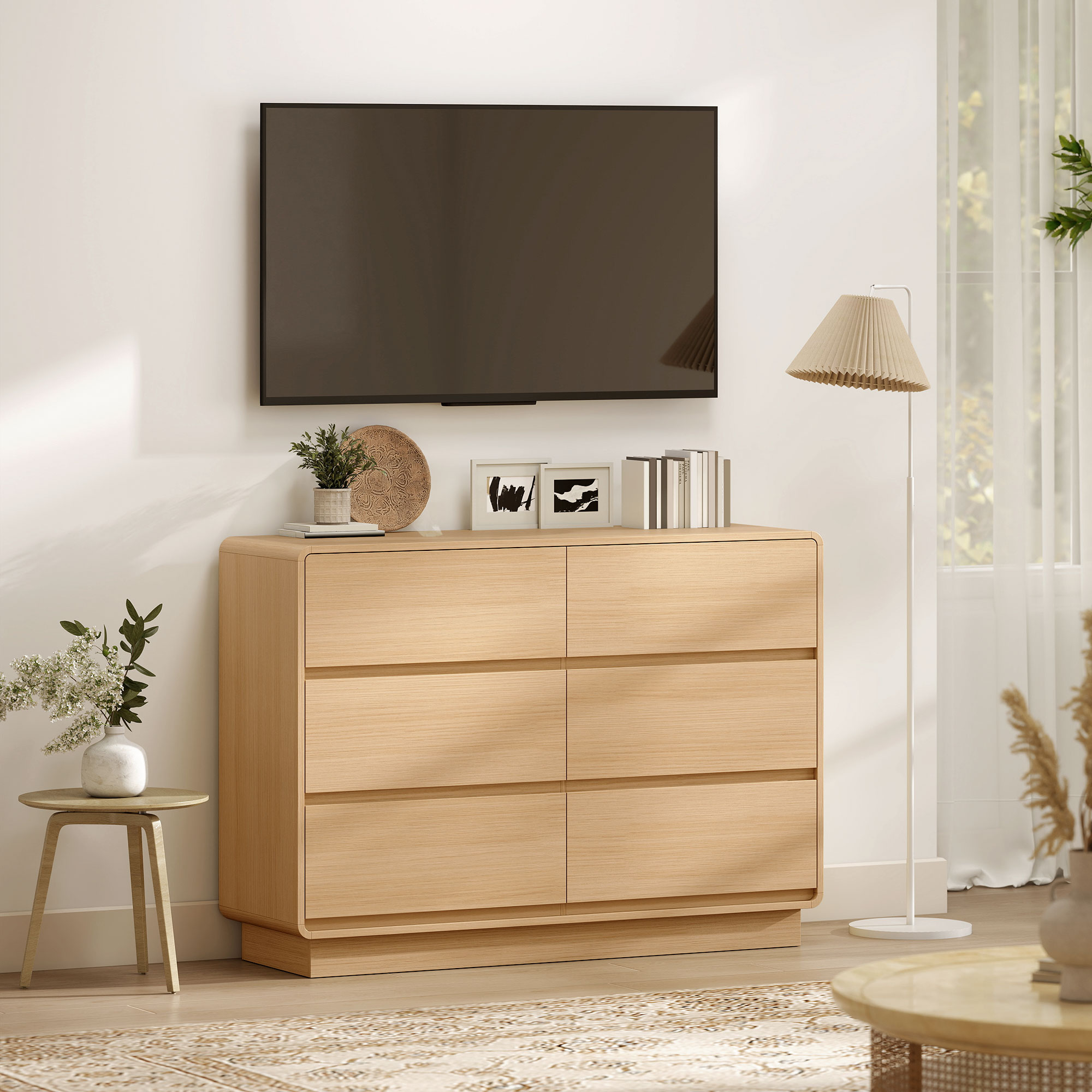 Una sala de estar luminosa con TV, cómoda y lámpara de pie.