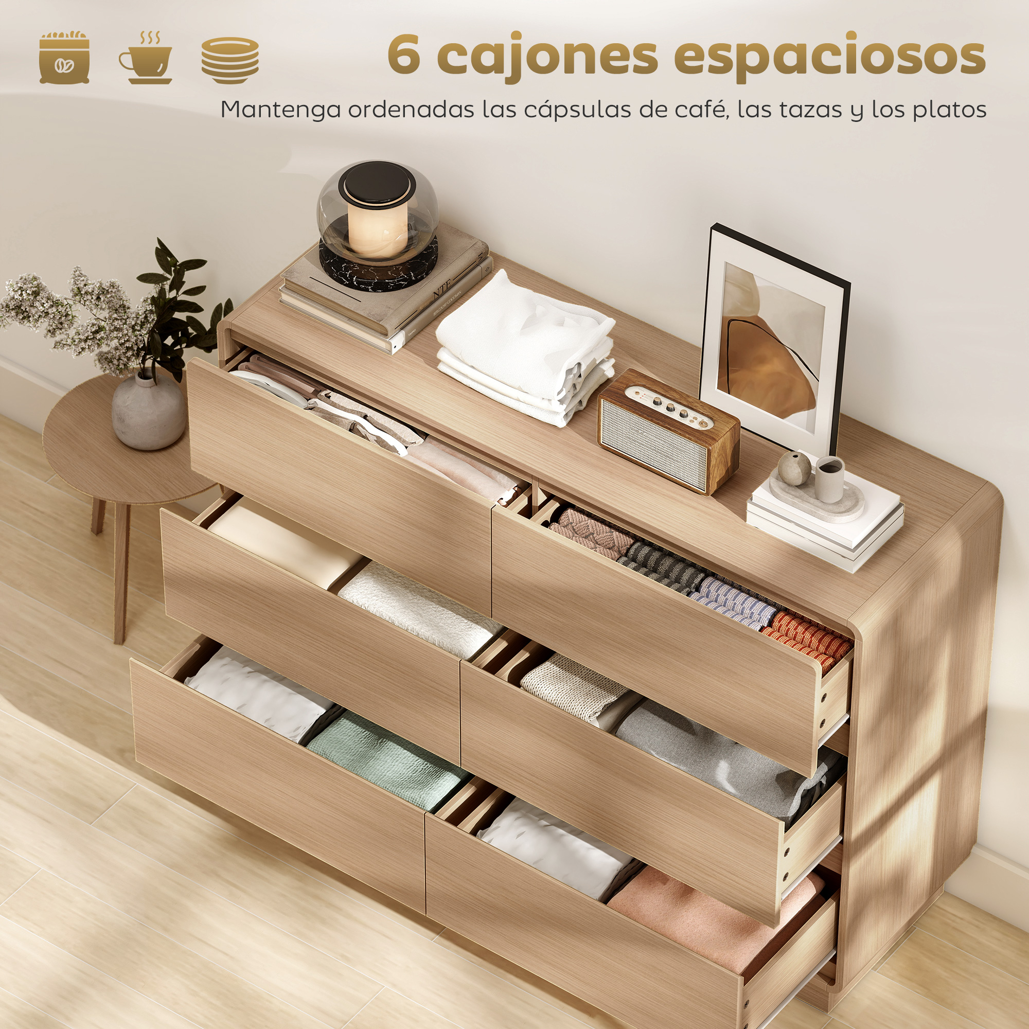 Cómoda de madera clara con cajones abiertos llenos de ropa y mantas.