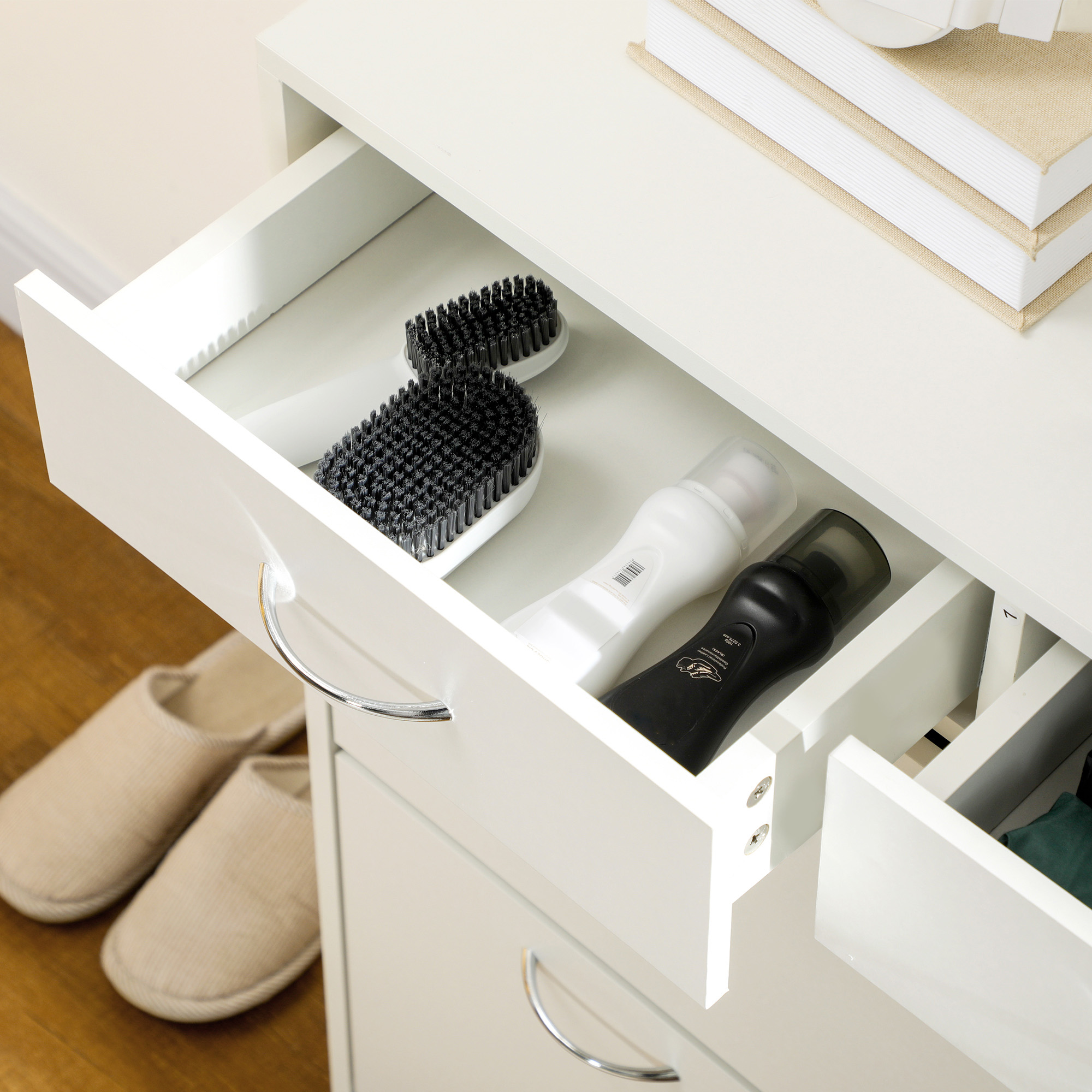 Mueble blanco abierto con dos cajones. Uno contiene cepillos y botellas.