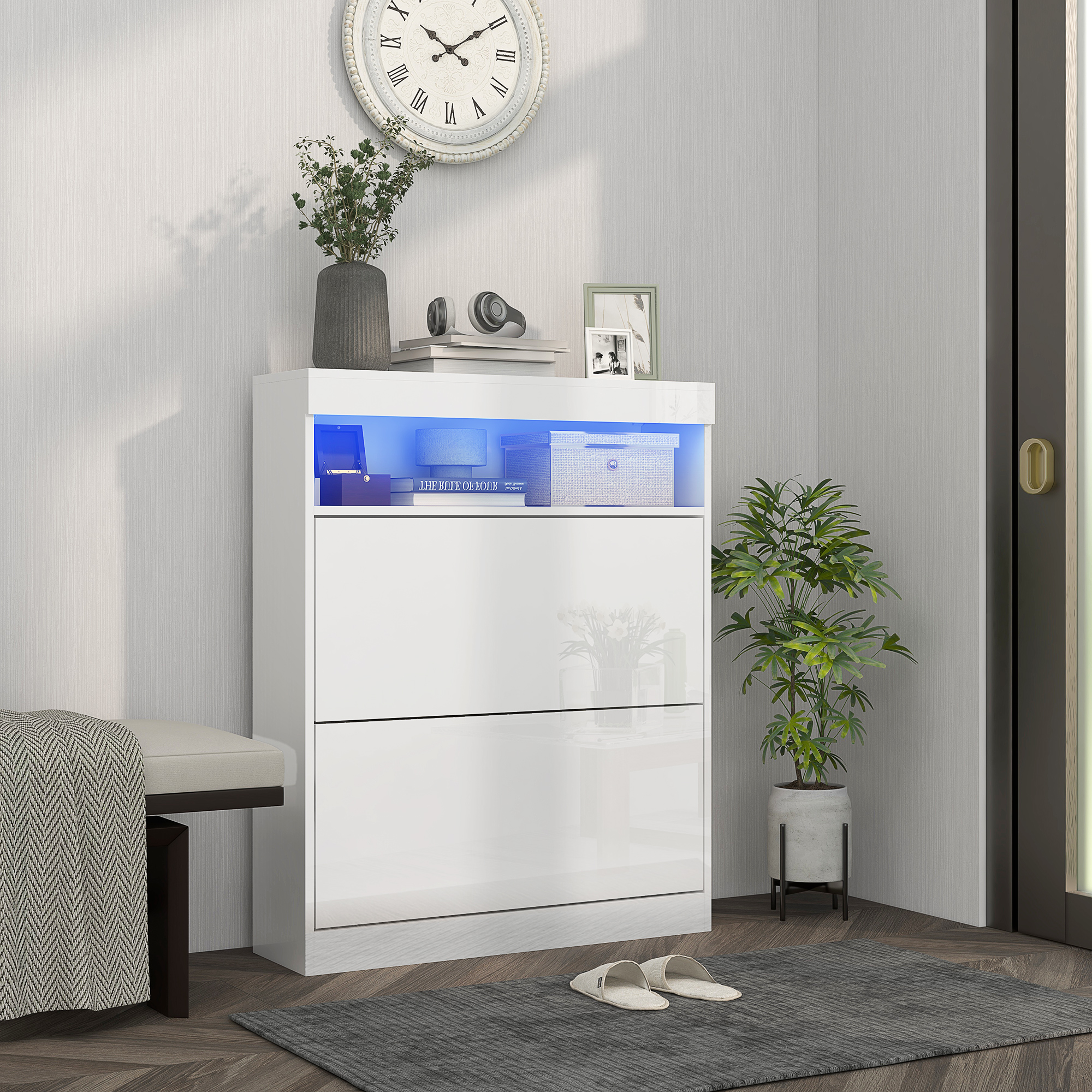 Un mueble blanco con iluminación LED se alza sobre un suelo de madera junto a una planta.
