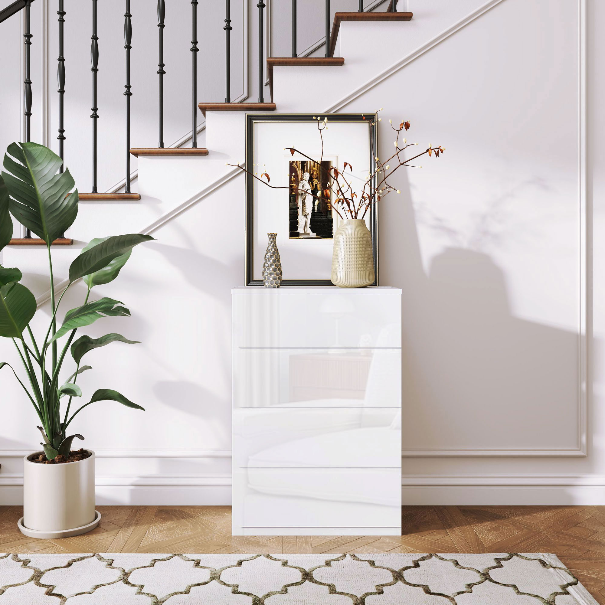 Cómoda blanca con arte enmarcado y planta, junto a escaleras.