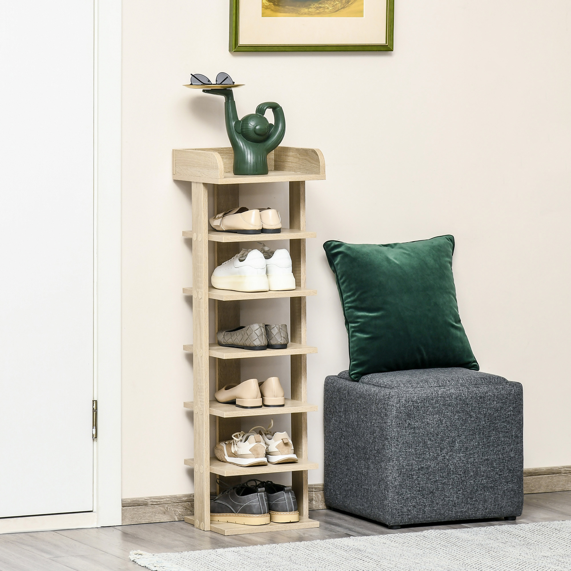 Zapatero de madera con zapatos, taburete con cojín verde y obra de arte.
