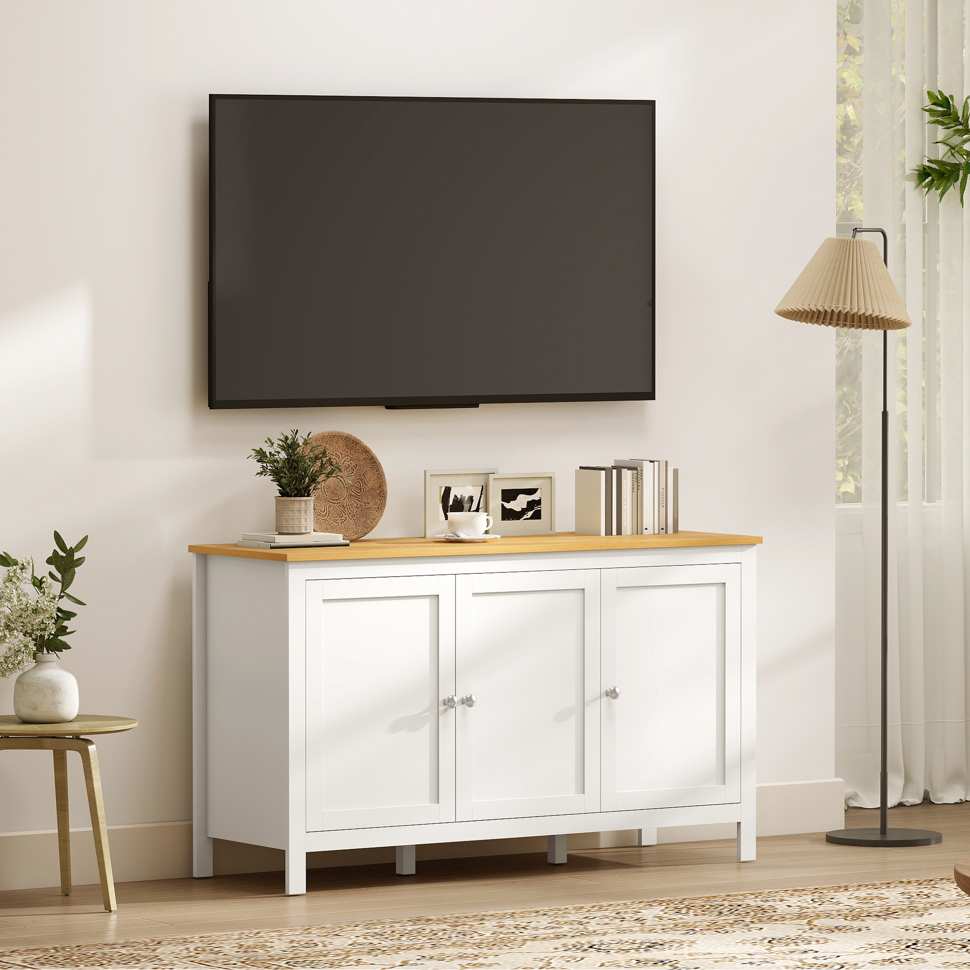 Un mueble blanco con tapa de madera debajo de un televisor. Mesa con jarrón a la izquierda, lámpara de pie a la derecha.