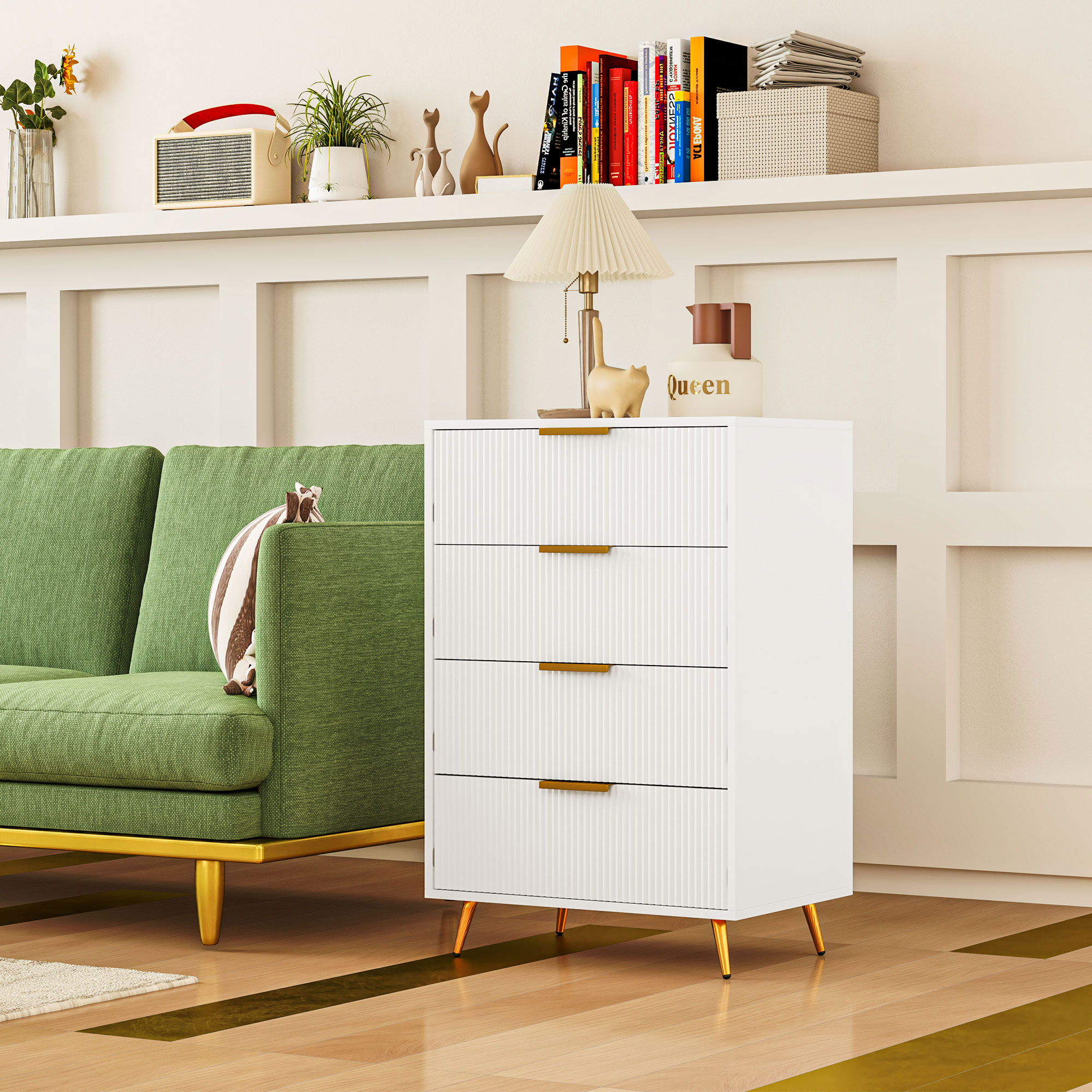 Un sofá verde, una cómoda blanca con tiradores dorados y una lámpara.
