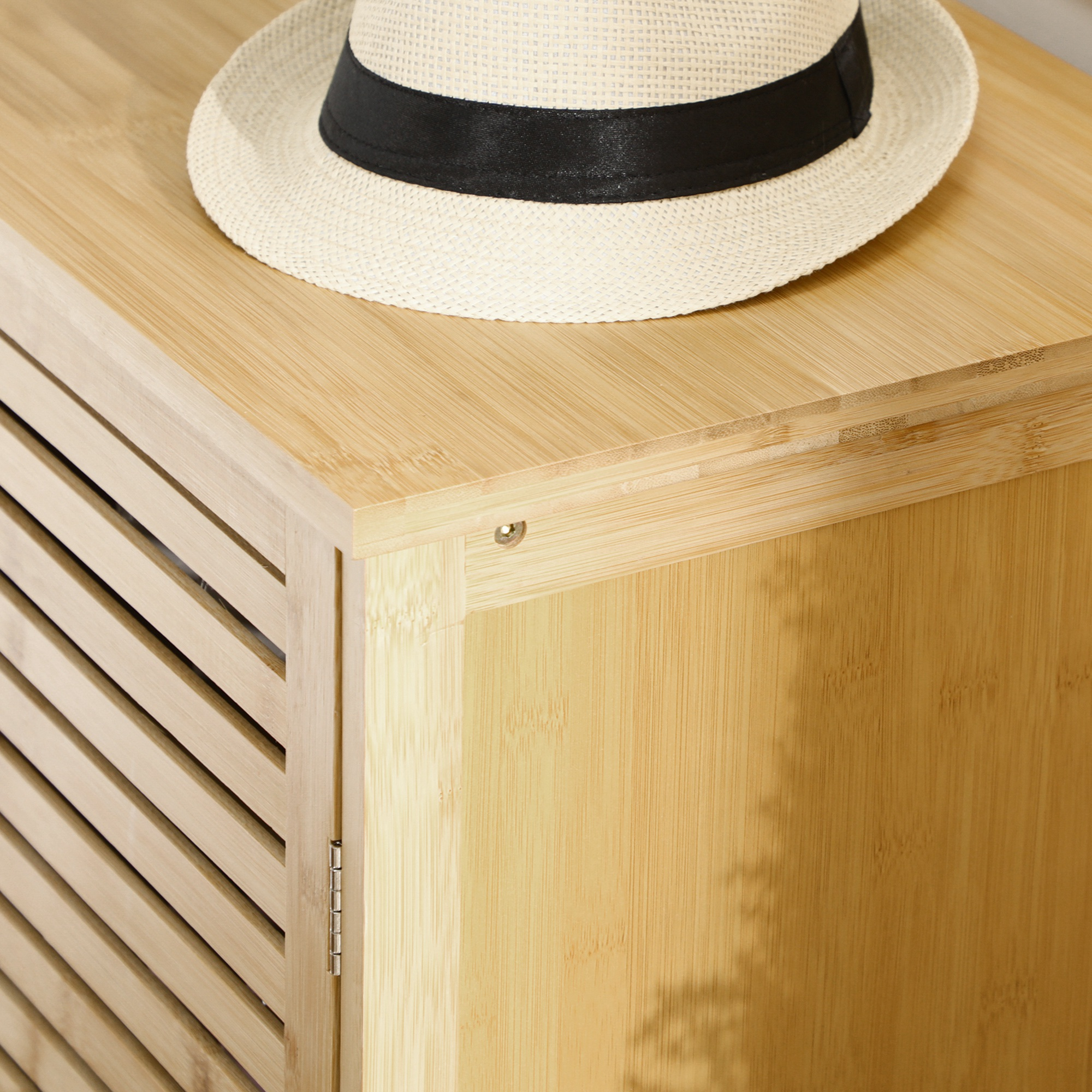 Un sombrero de paja con banda negra descansa sobre un mueble de madera.