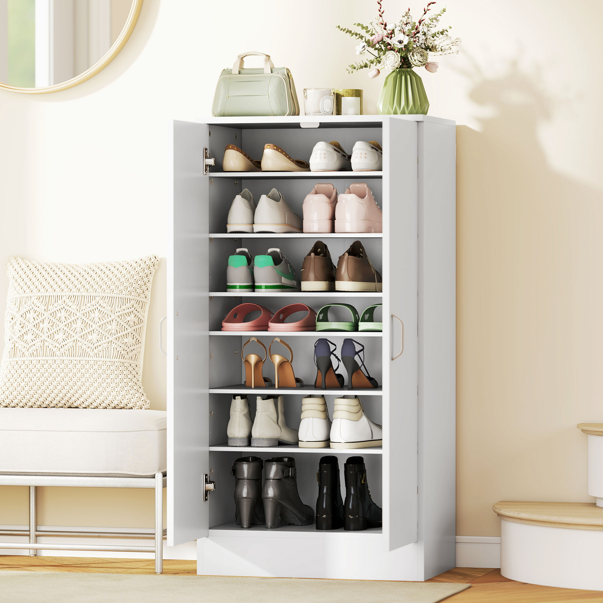 Un zapatero blanco con puertas abiertas, lleno de varios zapatos, botas y accesorios.