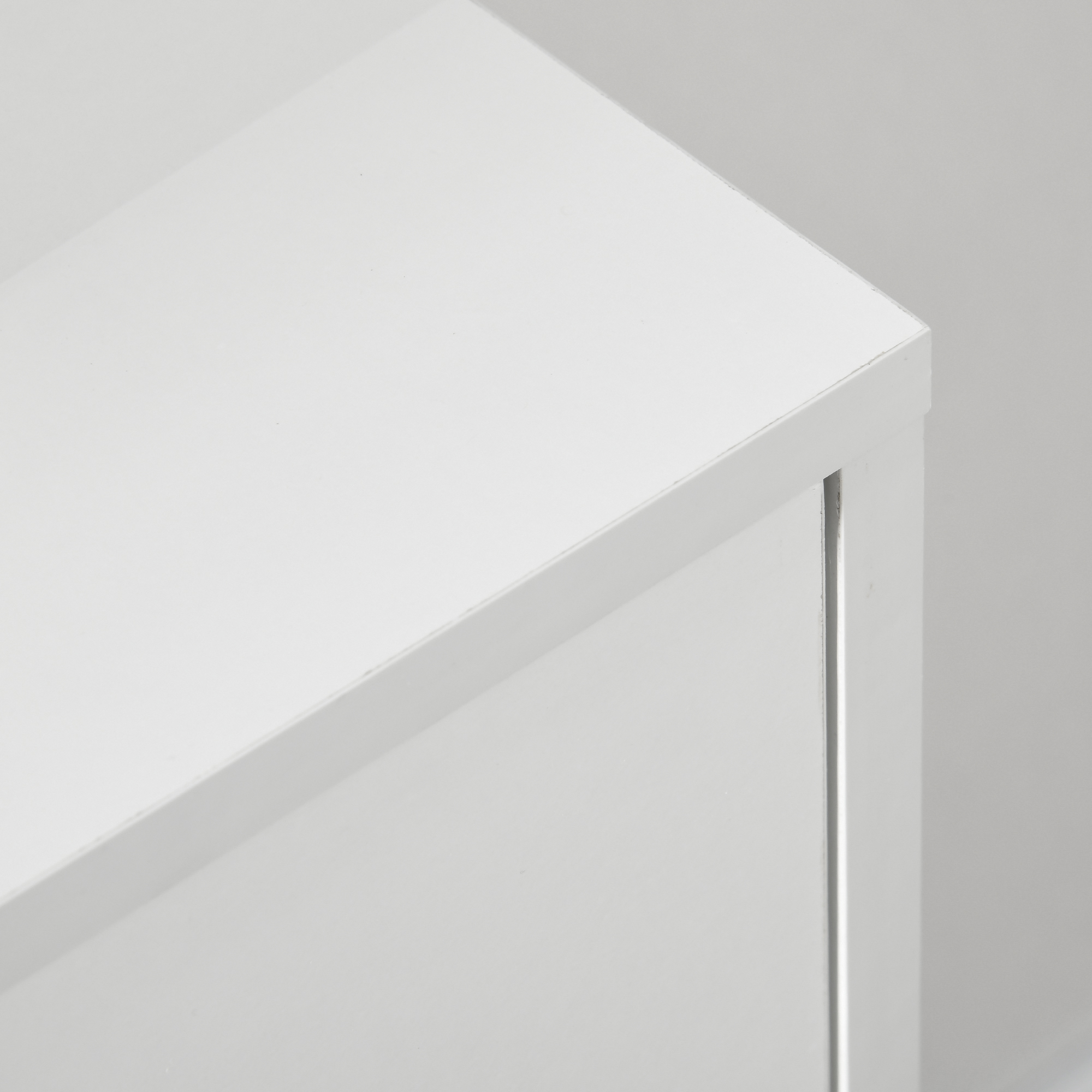 Primer plano de una superficie blanca con sombras y bordes.