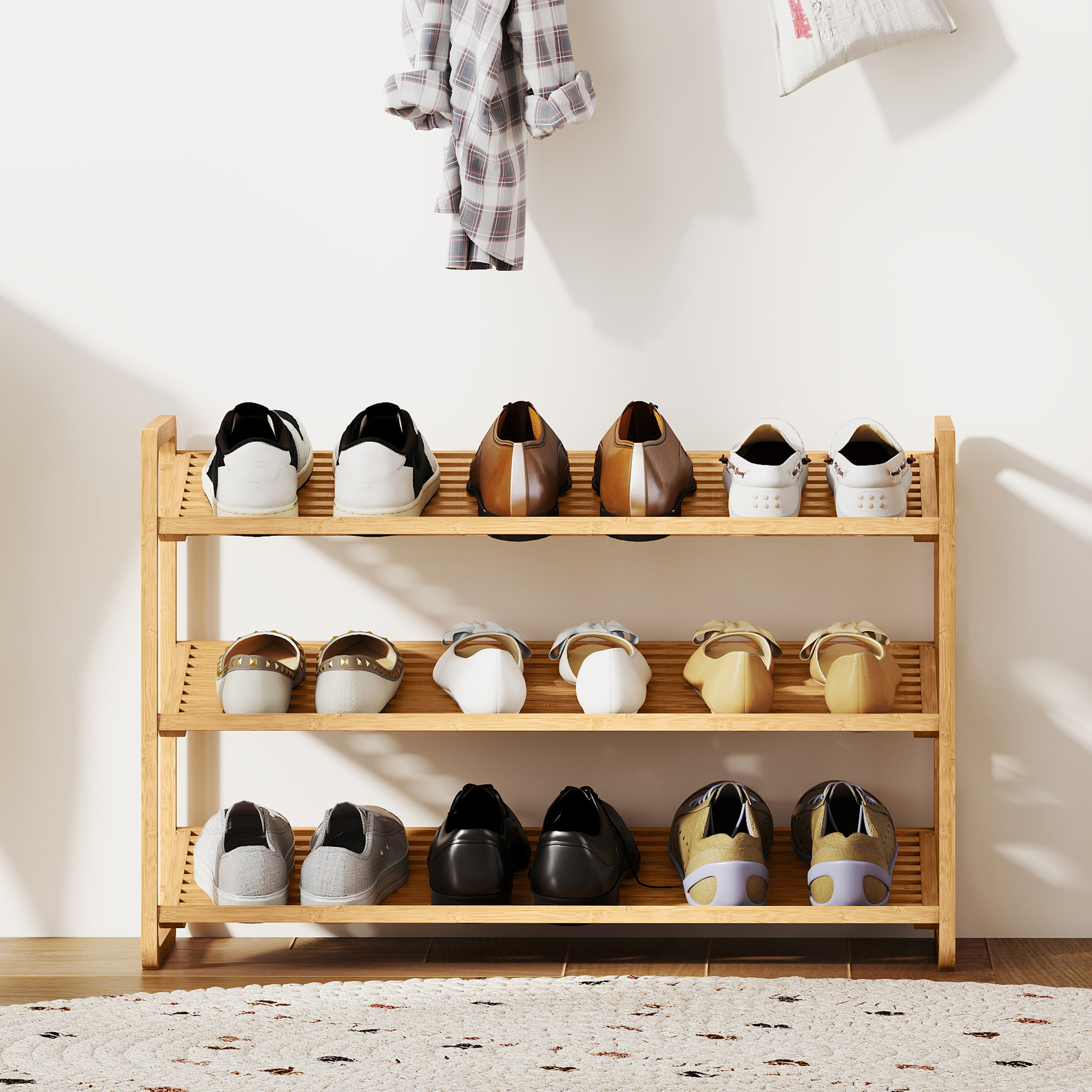 Un zapatero de madera con zapatos en tres niveles, junto a una pared con ropa.