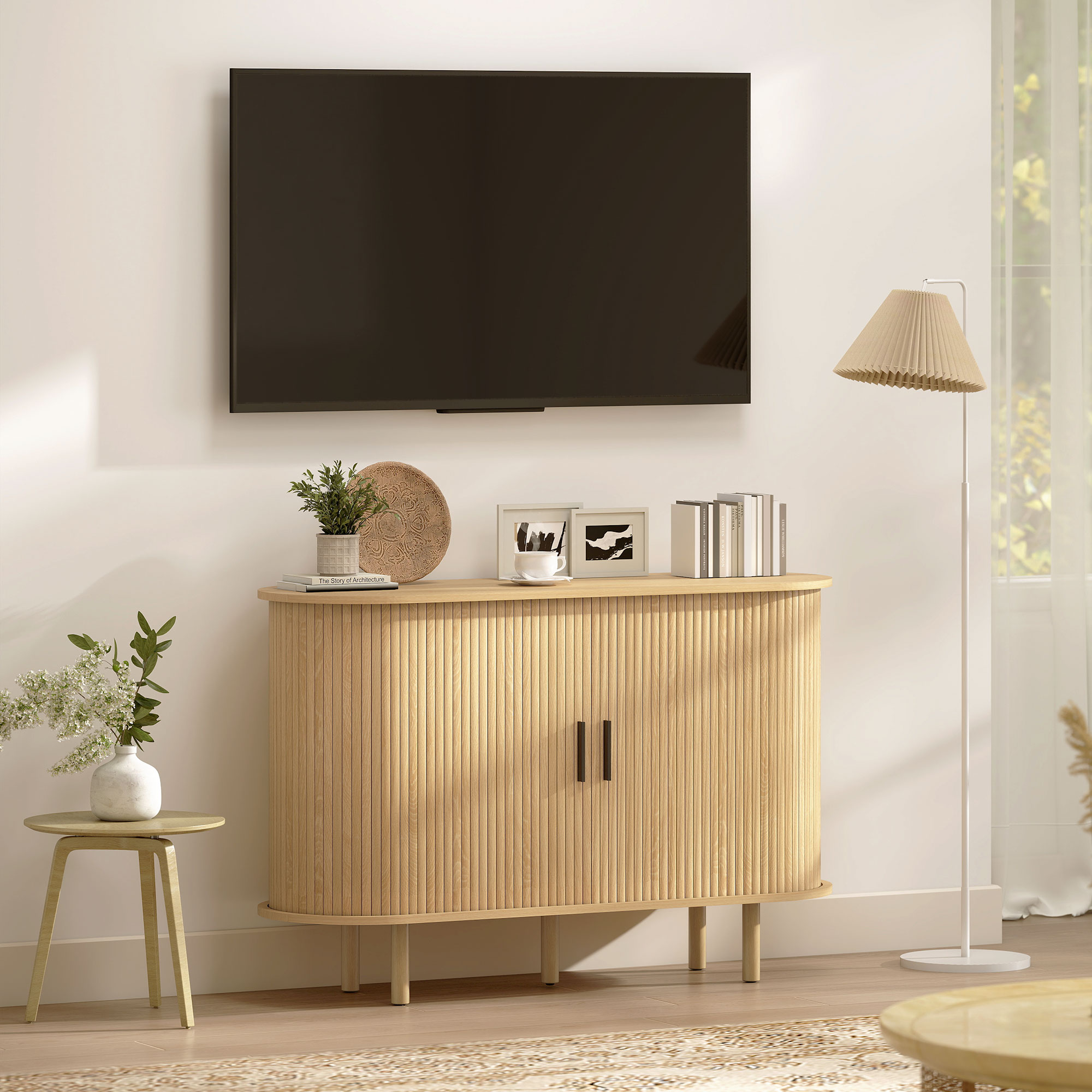 Una sala de estar con TV, aparador, lámpara y flores.