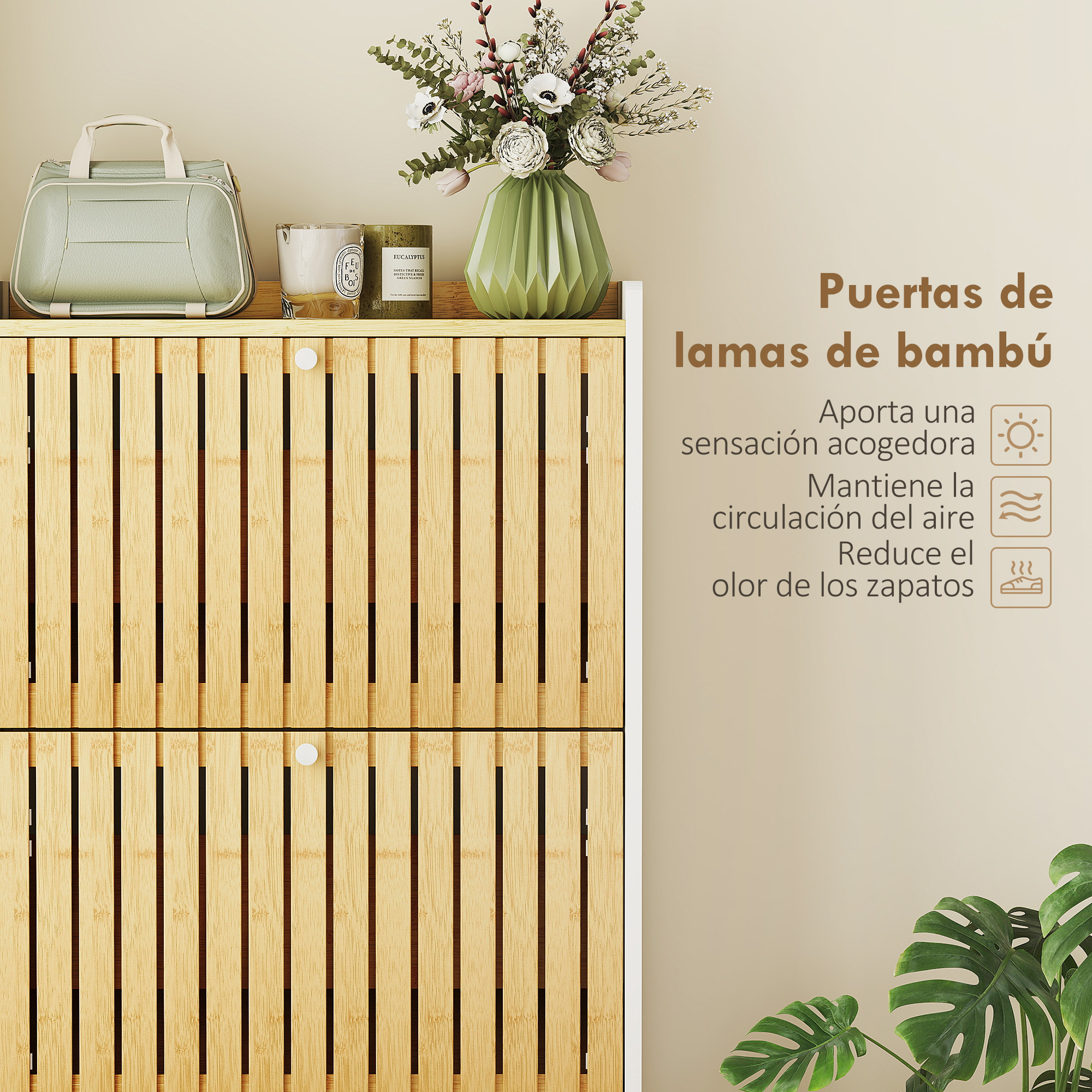 Un bolso verde, velas y un jarrón con flores sobre un mueble de madera.