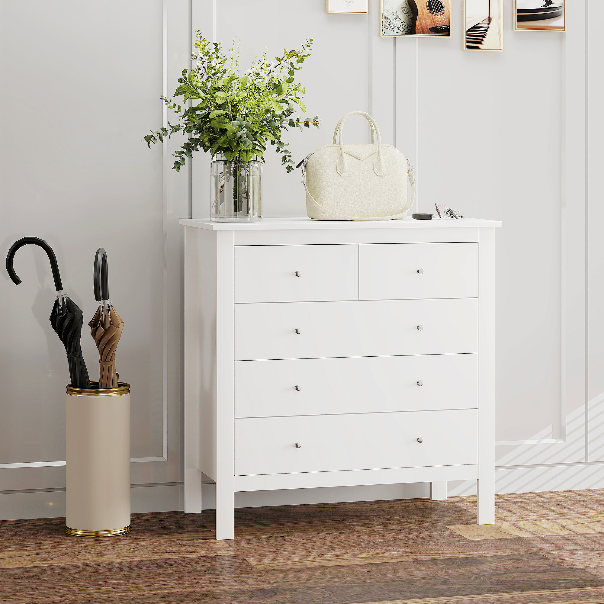 Una cómoda blanca con flores, bolso y paraguas al lado sobre suelo de madera.
