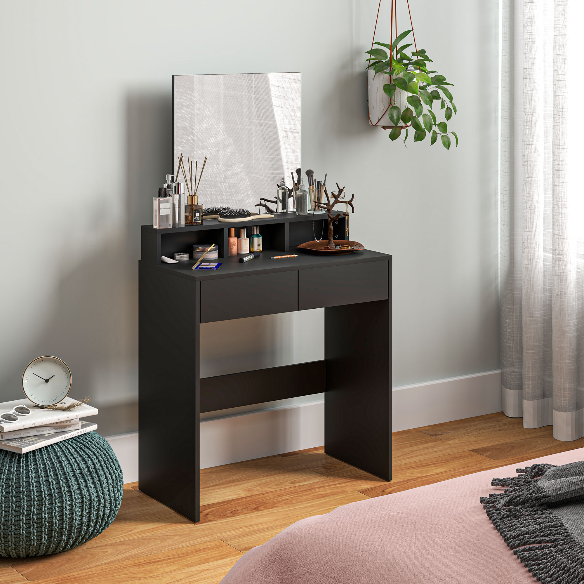Tocador negro con espejo, maquillaje, planta y reloj sobre puf.