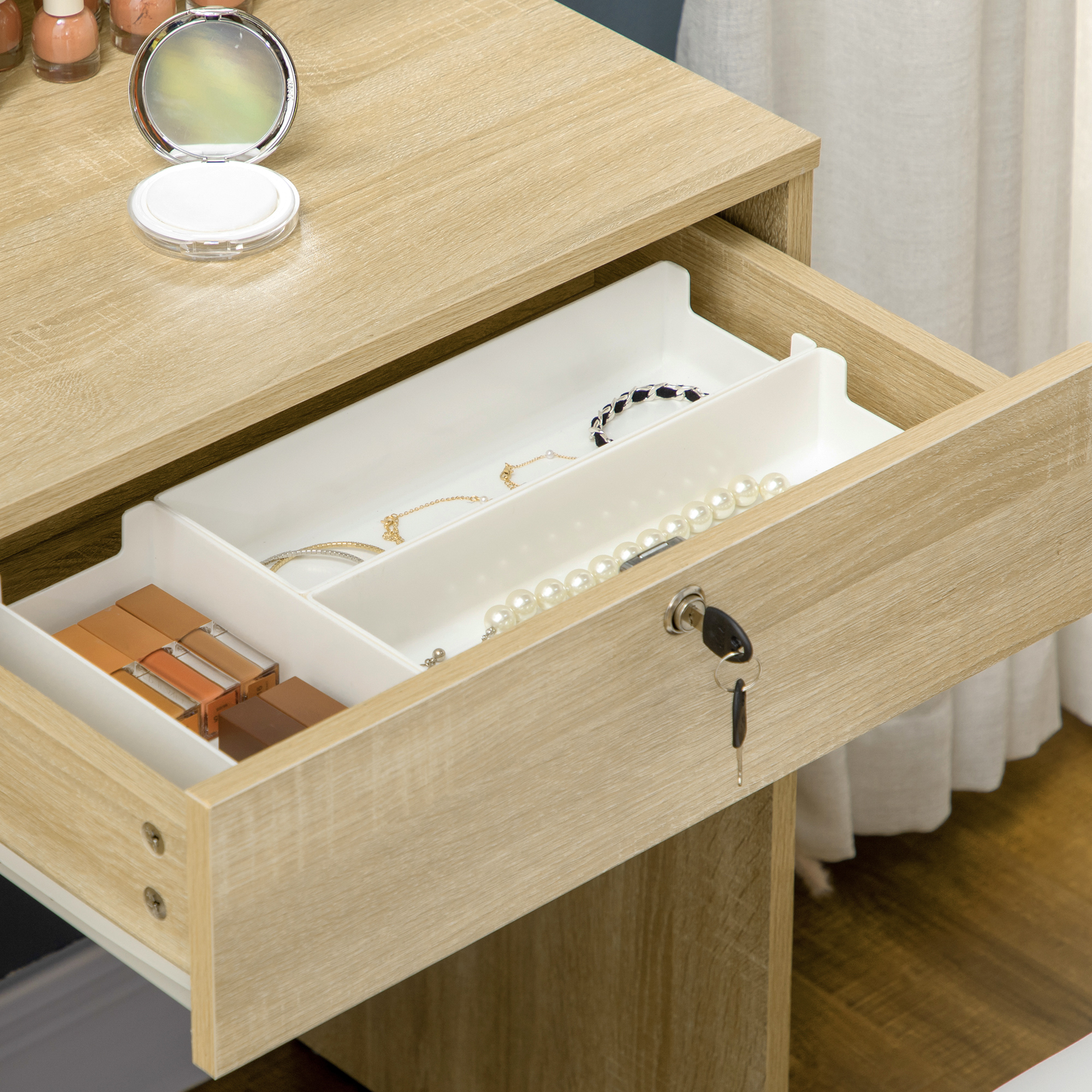 Cajón de madera abierto con joyas y cosméticos, llave puesta.