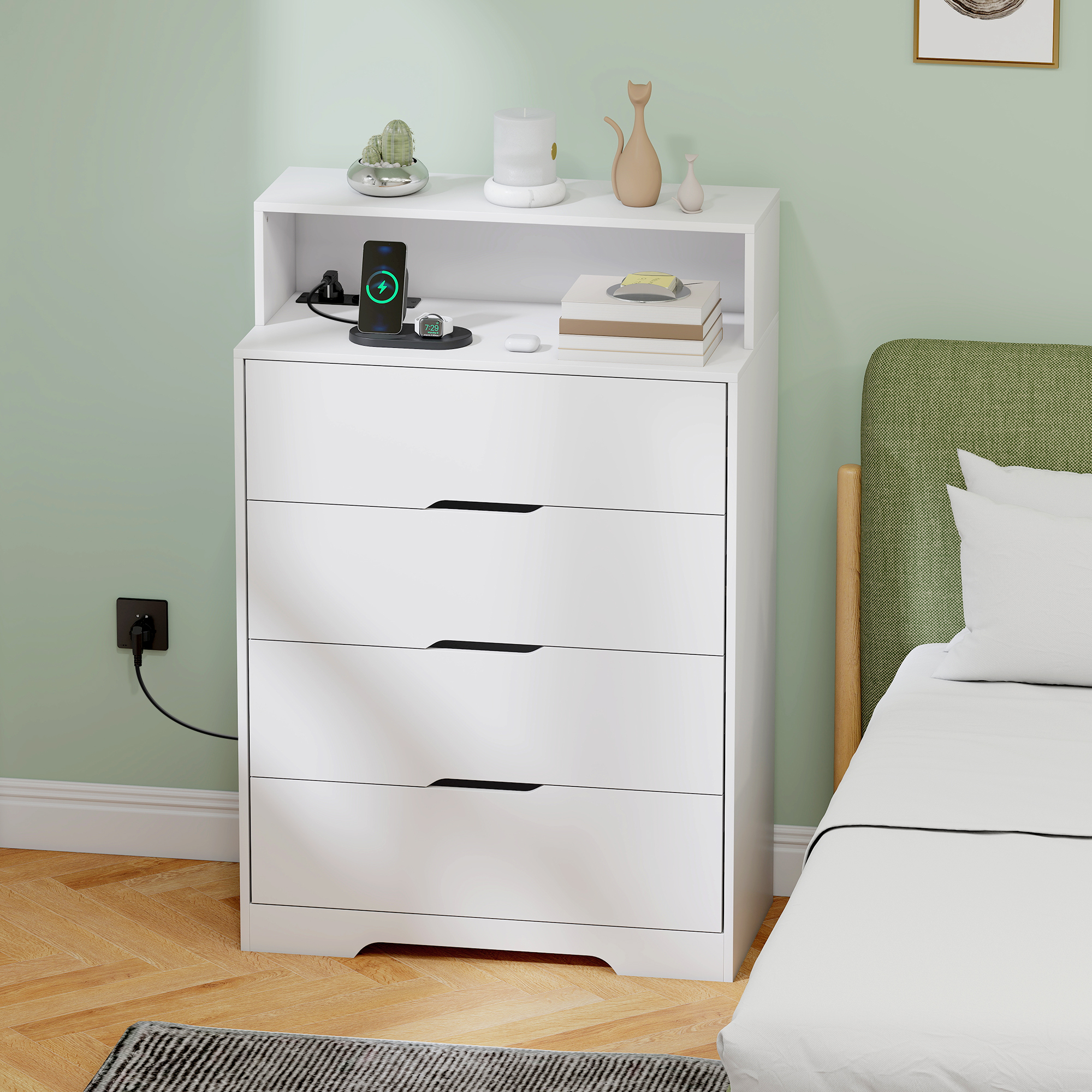 Una mesita de noche blanca con función de carga junto a una cama con cabecero verde.