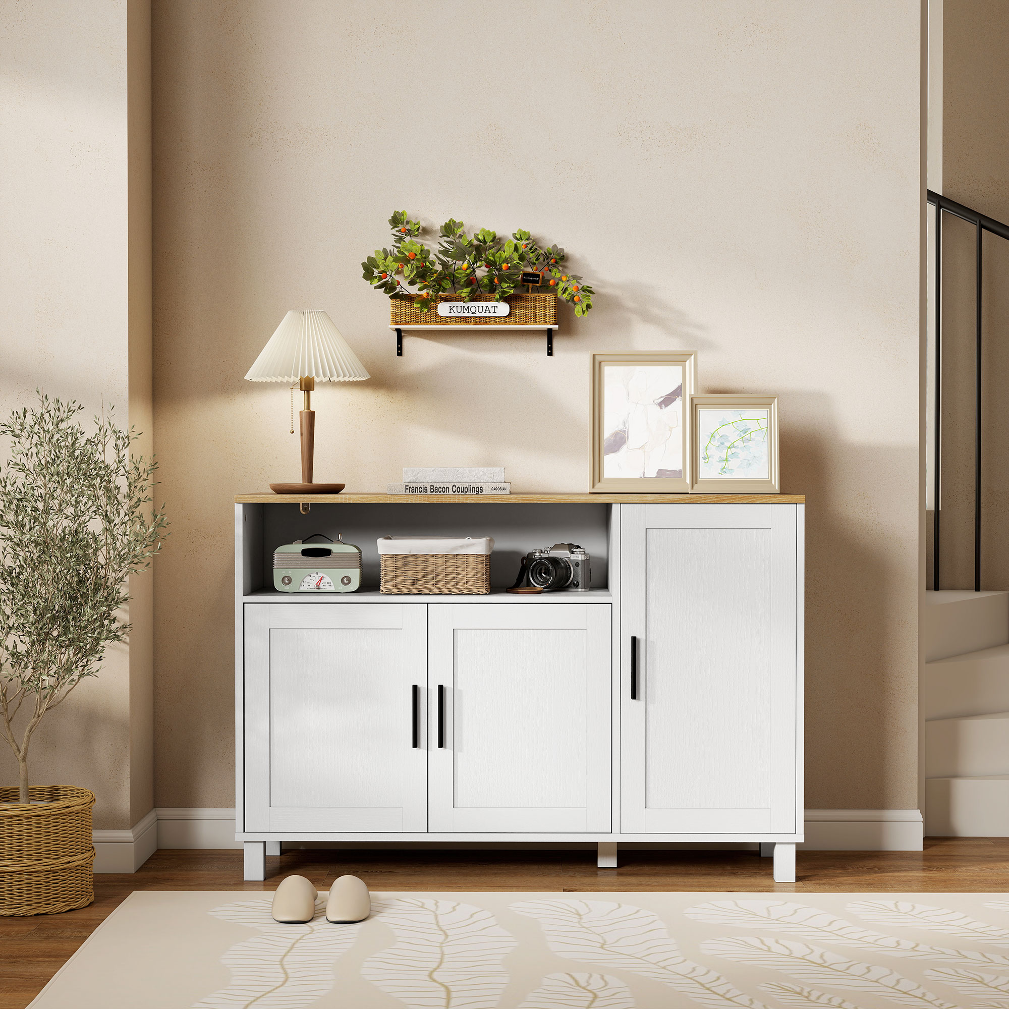 Un aparador blanco con tapa de madera, lámpara, radio, cámara y plantas.