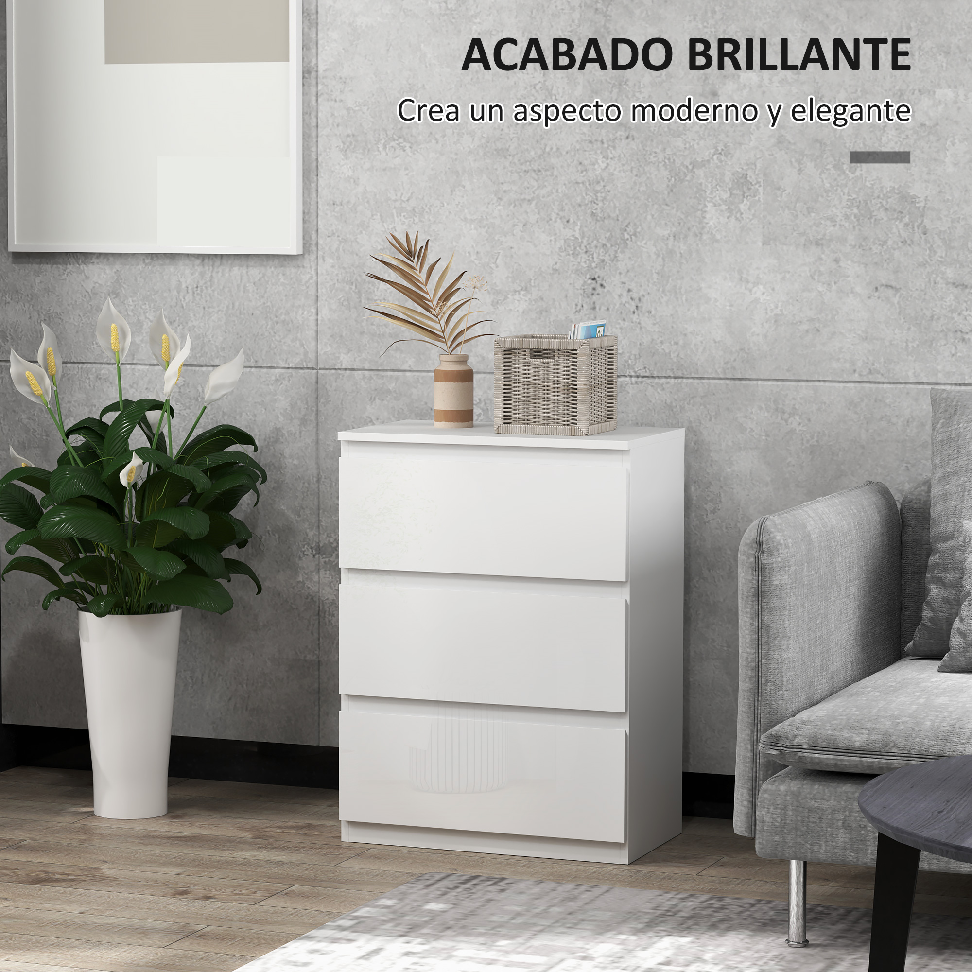 Una cómoda blanca de tres cajones junto a un sofá gris.