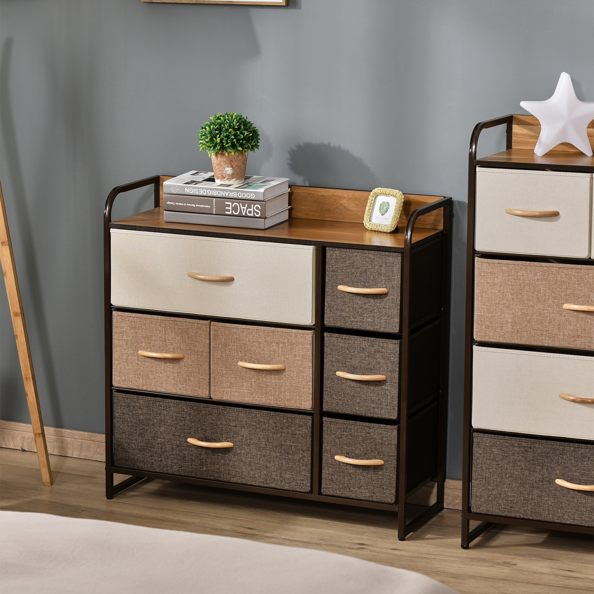 Una cómoda estrecha con cajones de tela y tiradores de madera junto a una lámpara de estrella.