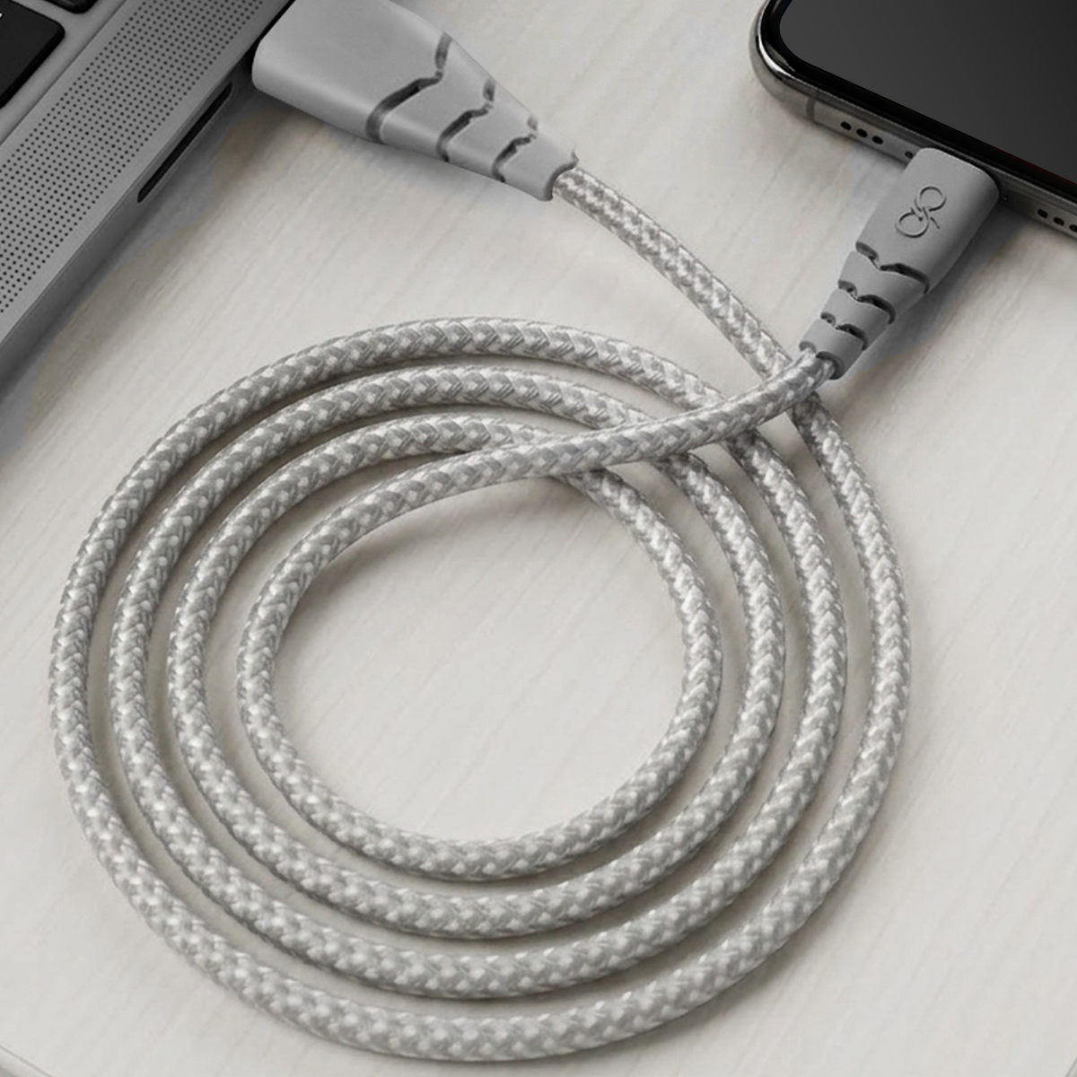 Câble de chargement gris connectant un ordinateur portable et un smartphone.